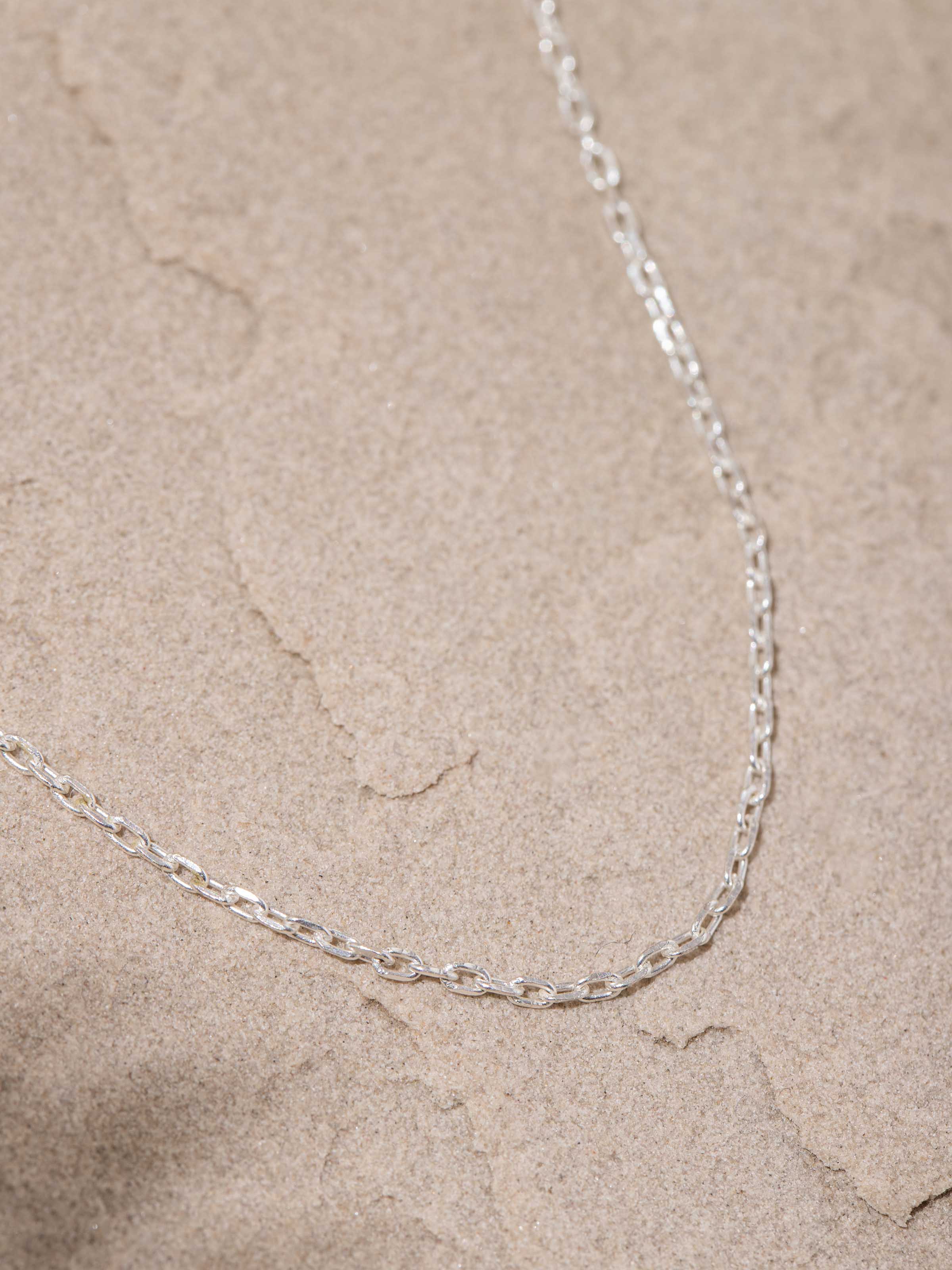 Close-up detail emphasizing the chain’s silverwork and finish