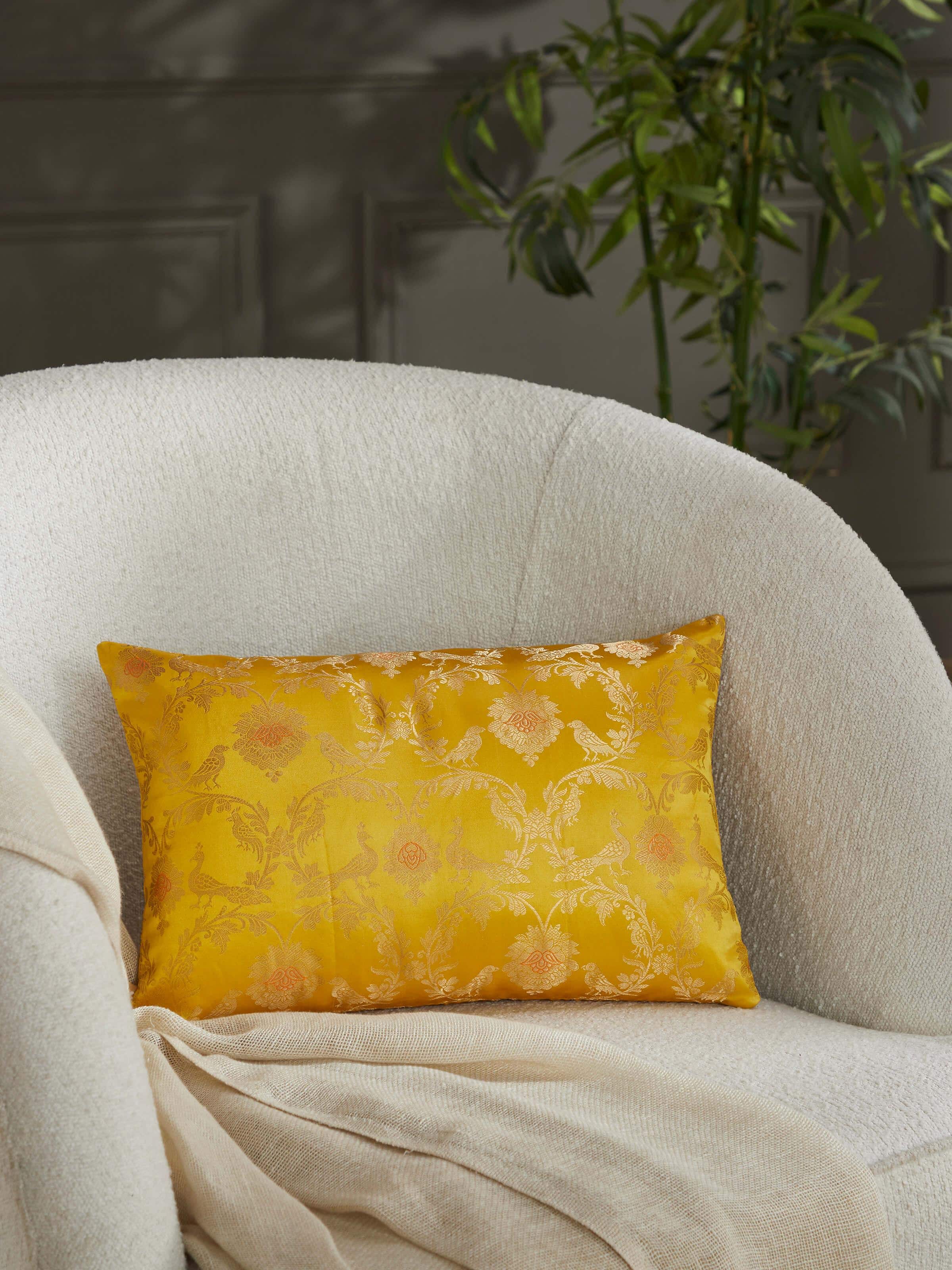 Lifestyle shot of luxurious yellow silk cushion in a styled traditional decor setup.