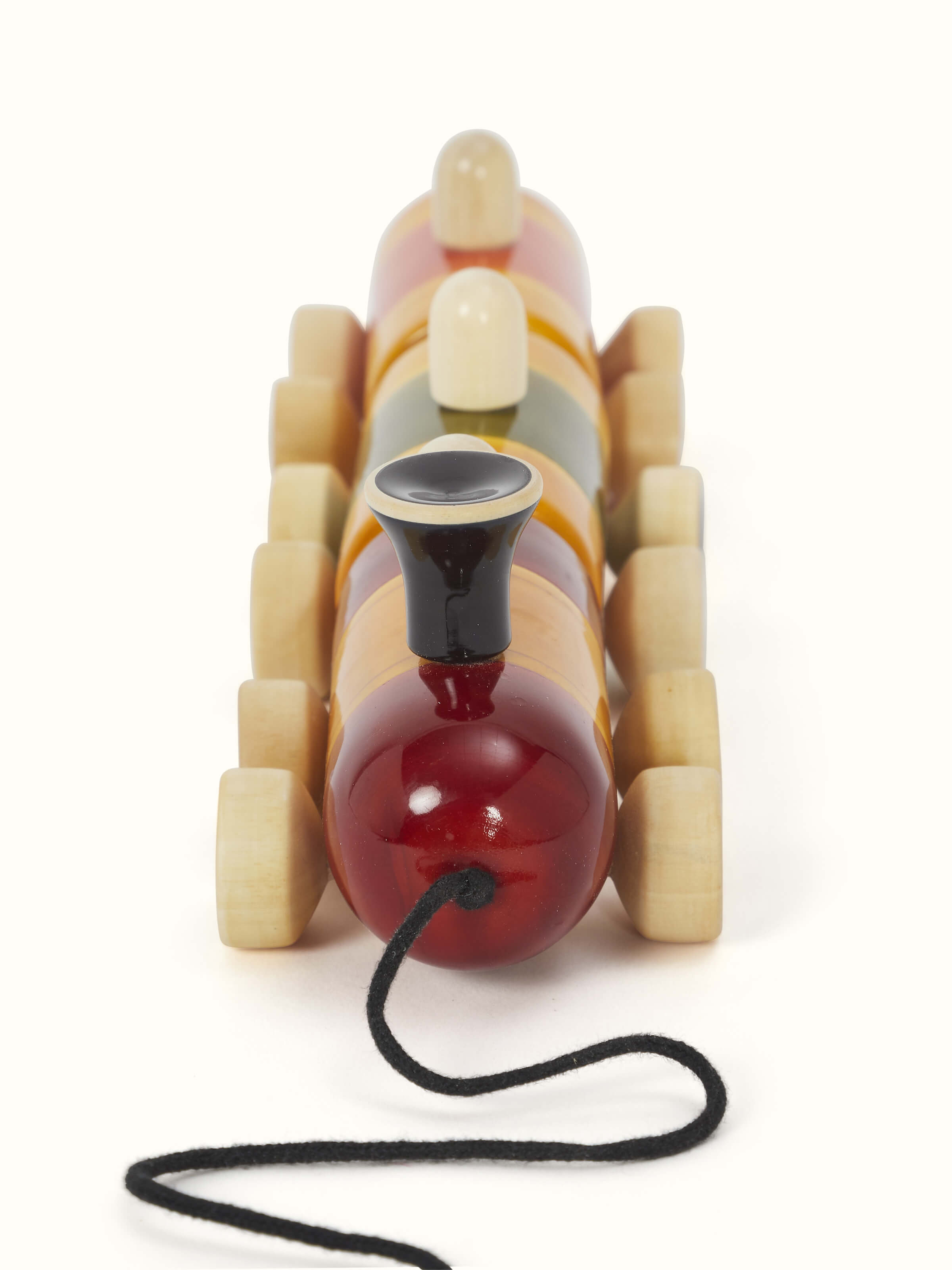 Angled view of Channapatna White Wood Pom Pom Rail Toy emphasizing its playful design and high-quality wooden finish