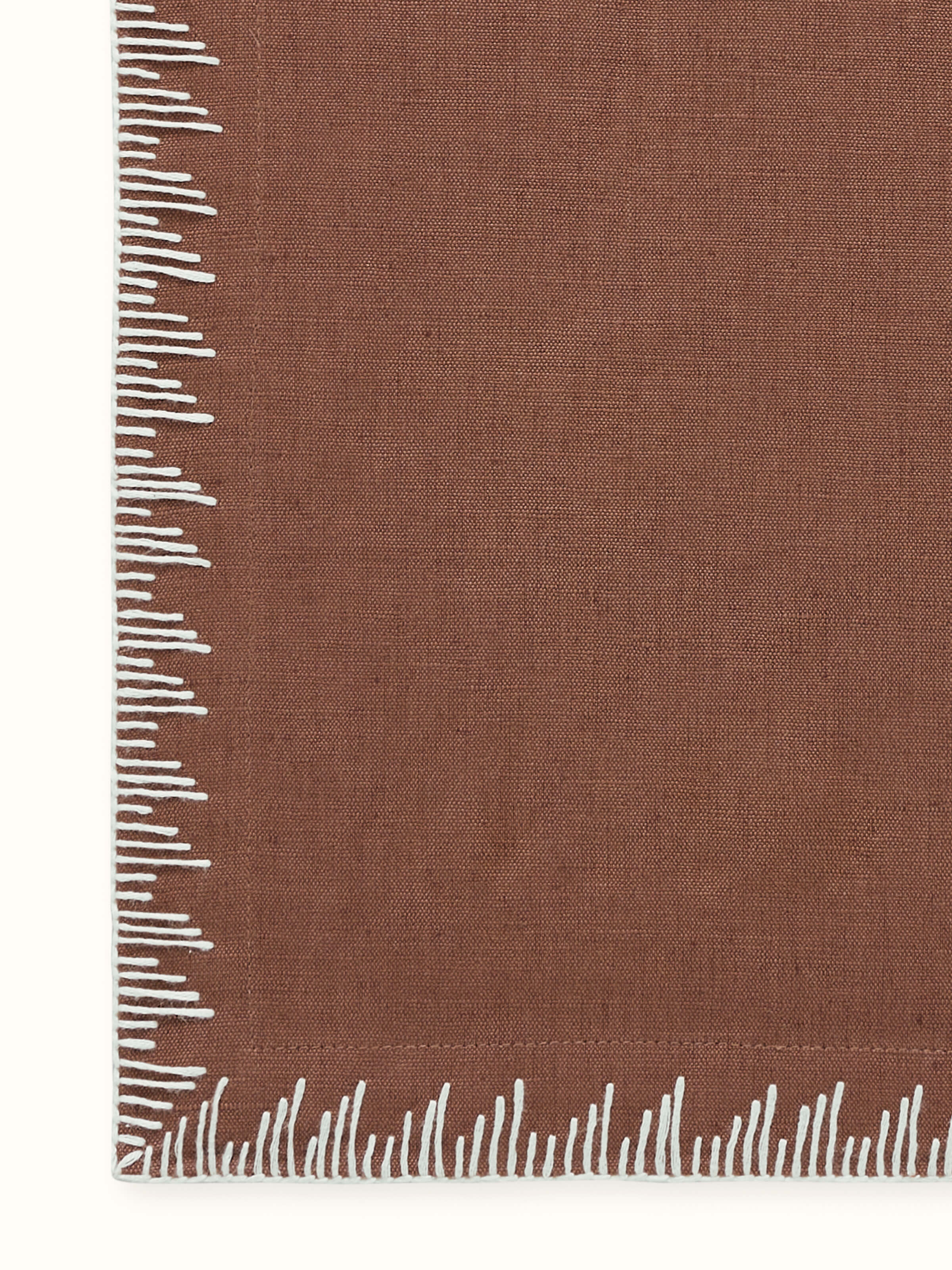 Corner and fabric texture detail of brown edge stitch table mat