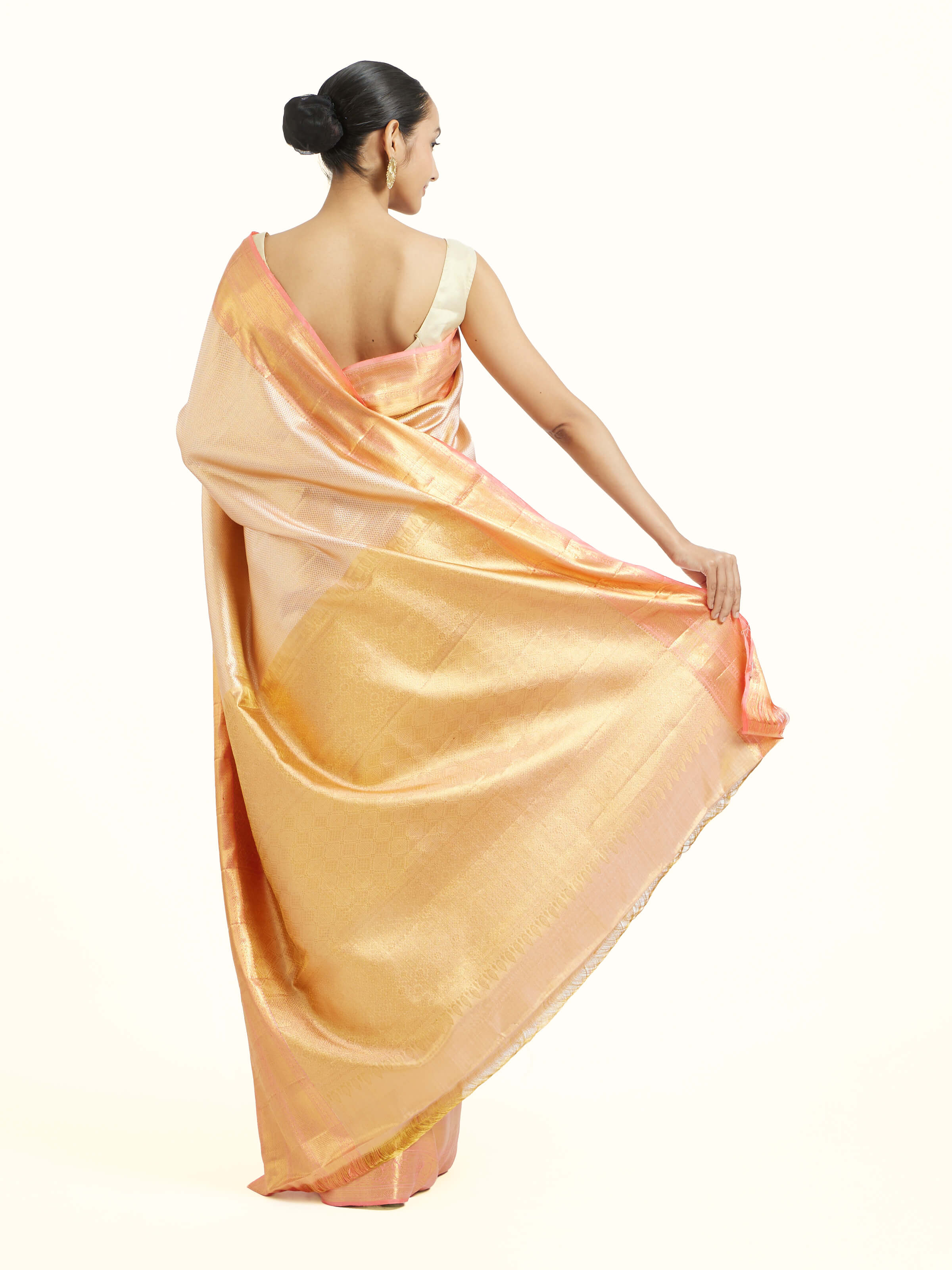 Back view of beige silk Kancheepuram saree displaying ornate pallu