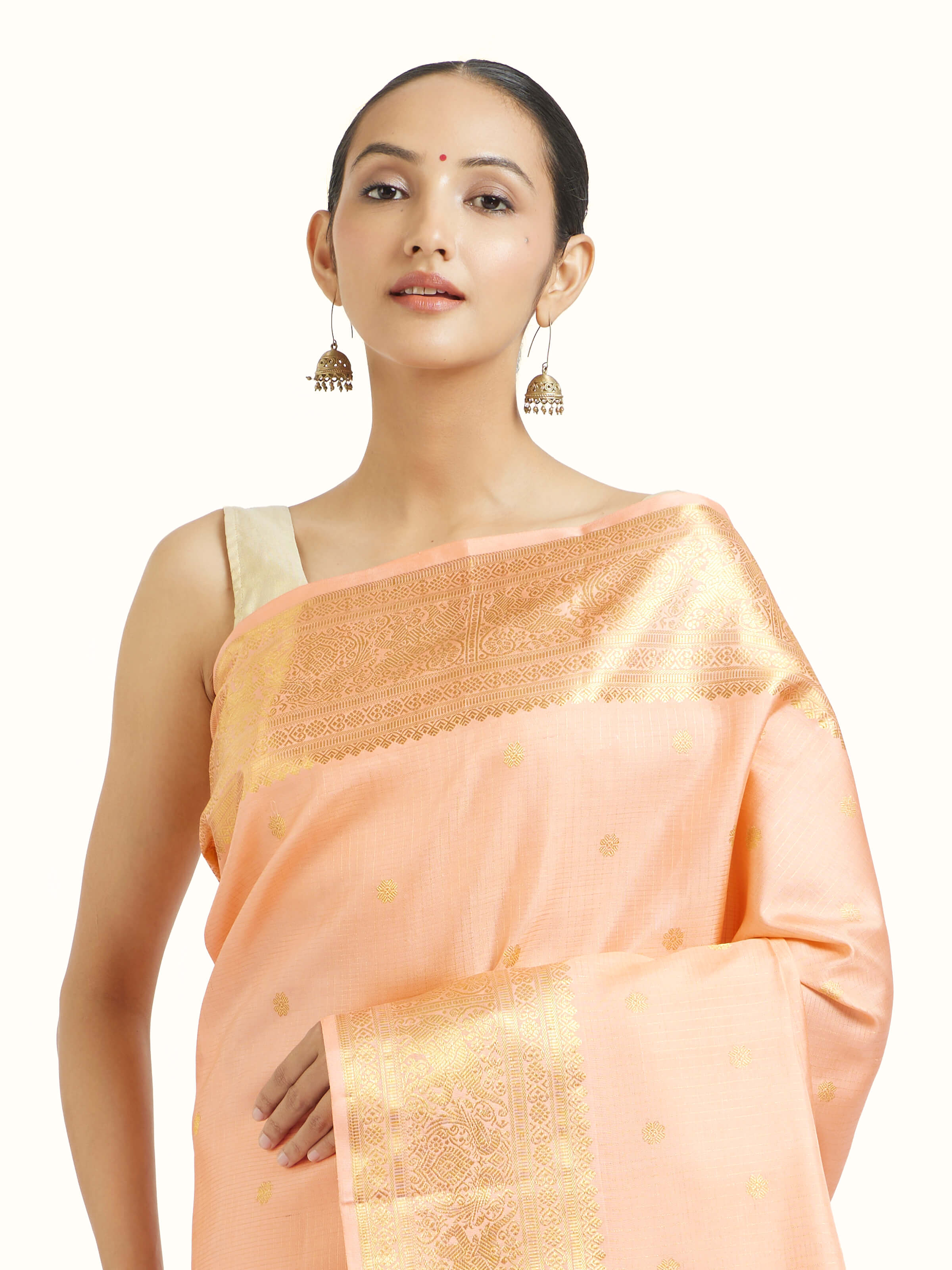 Angled view of light pink silk Kancheepuram saree highlighting traditional weave and sheen