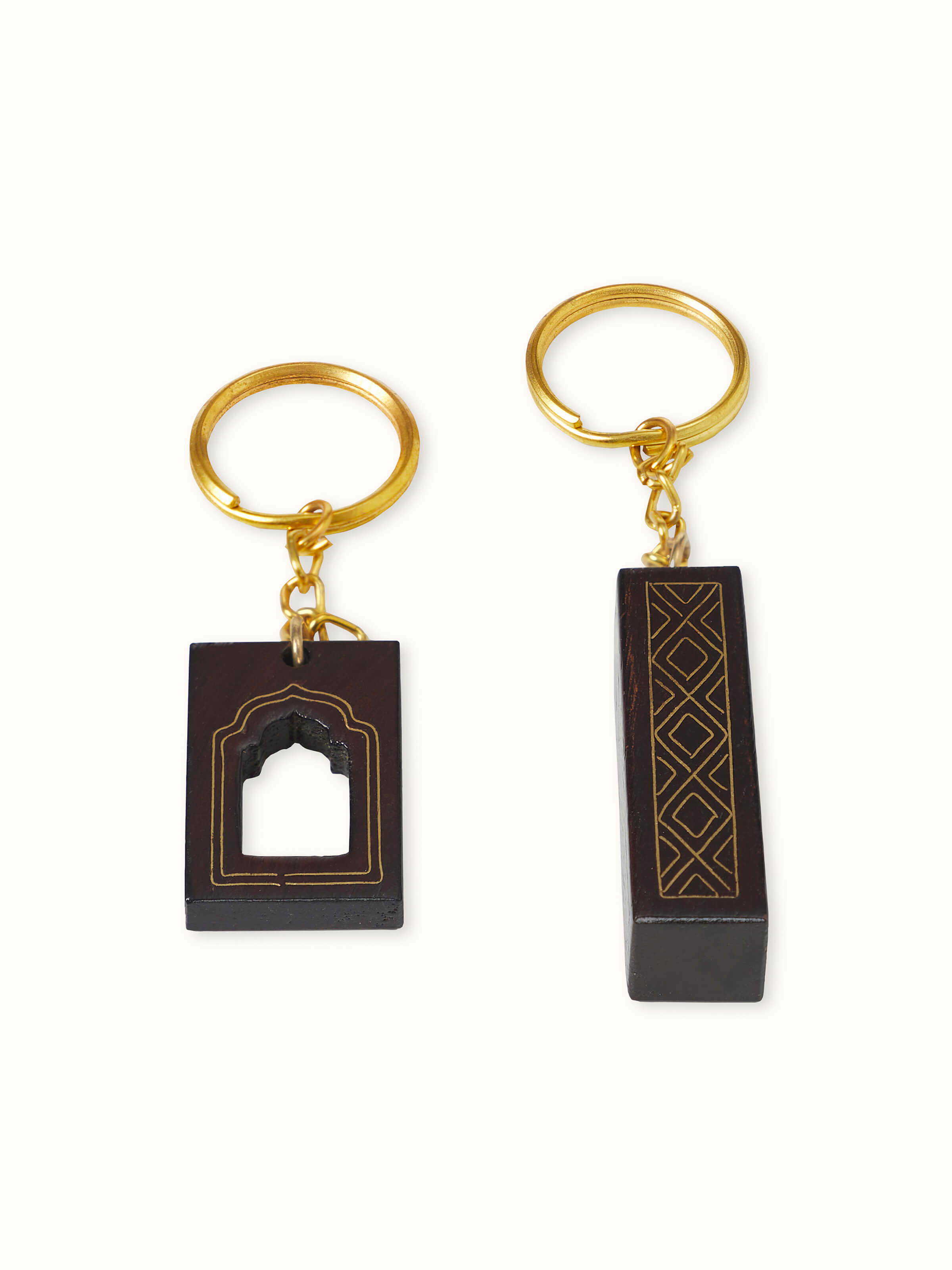 Angled view of Tarkashi Sheesham Wood & Brass Arch Keychains by Swadesh showcasing their smooth finish and decorative brass accents.