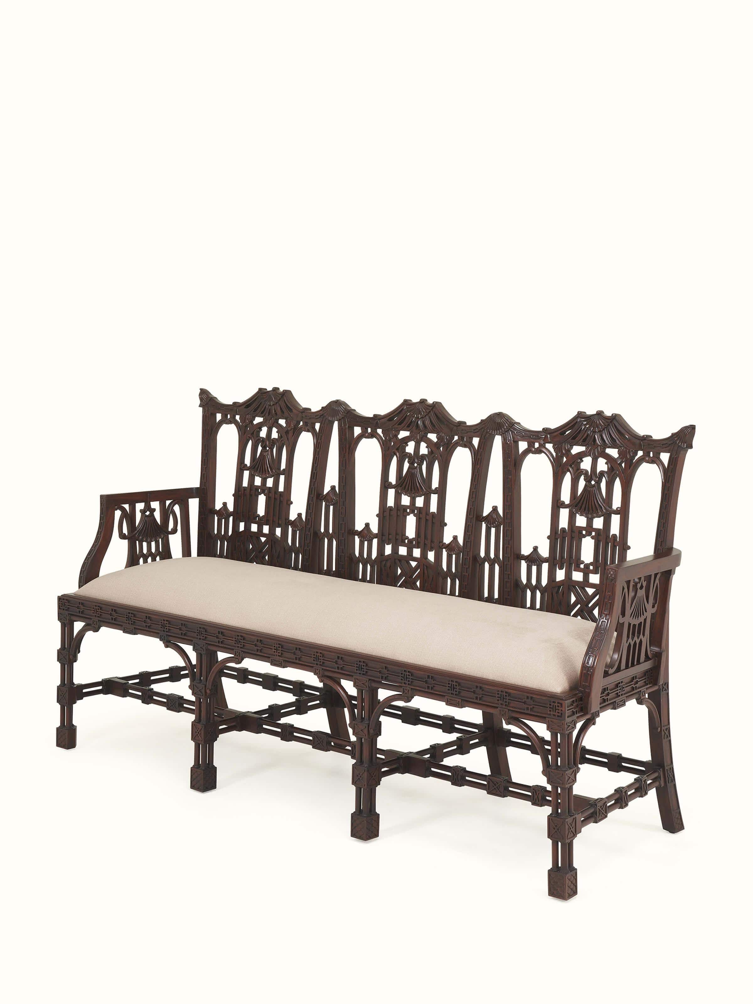 Angle view of upholstered mahogany wood 3-seater sofa highlighting rolled arms and leg details