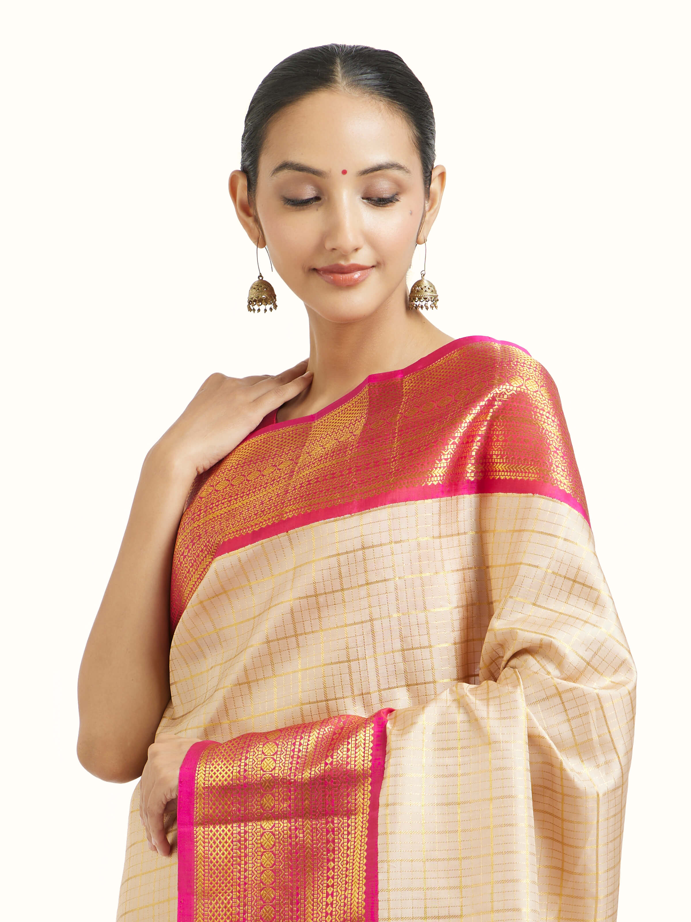 Angled view of cream silk Kancheepuram saree highlighting traditional weave and sheen