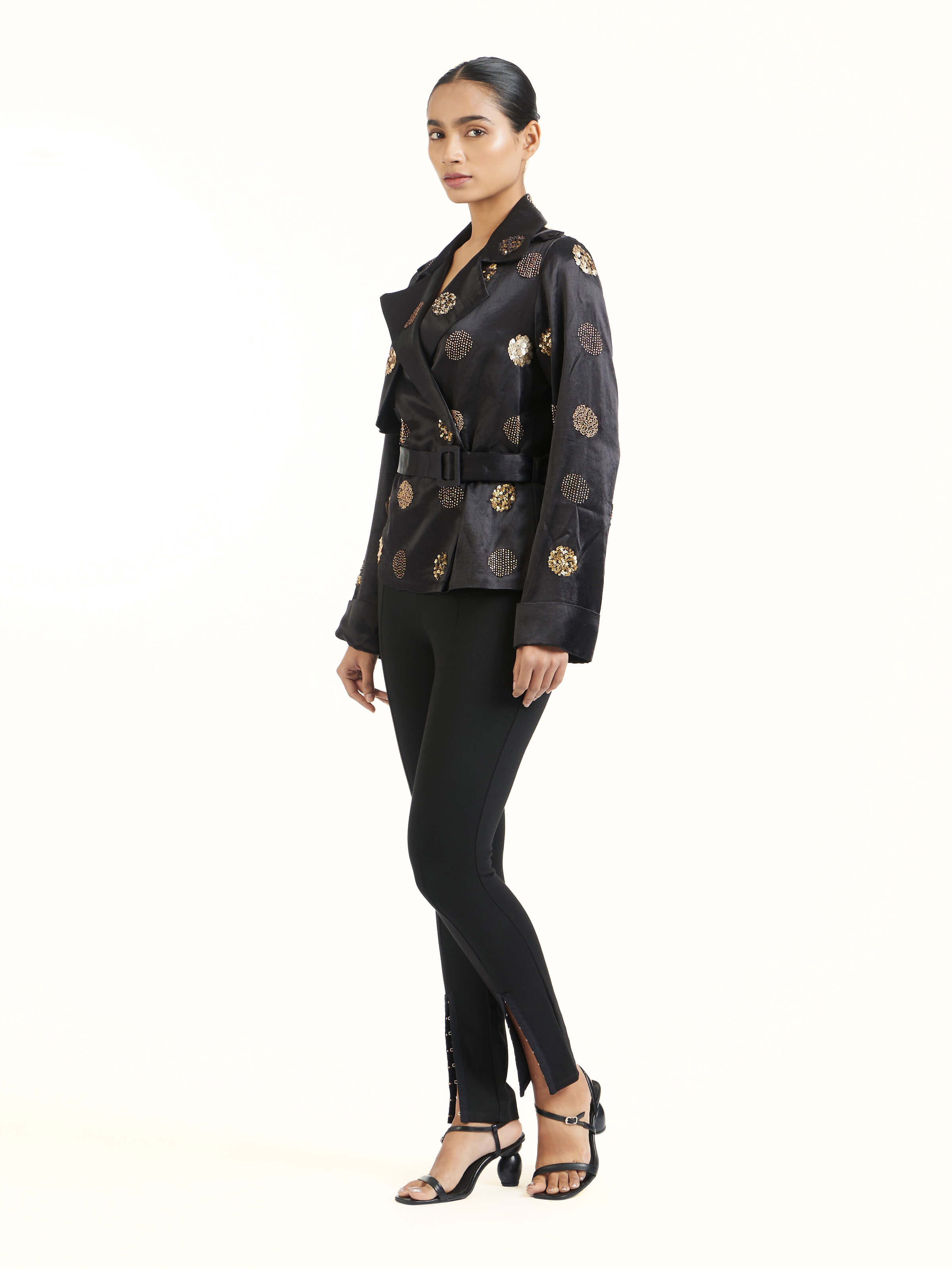 Side view of black hand embroidered dotted gold jacket showcasing tailored fit