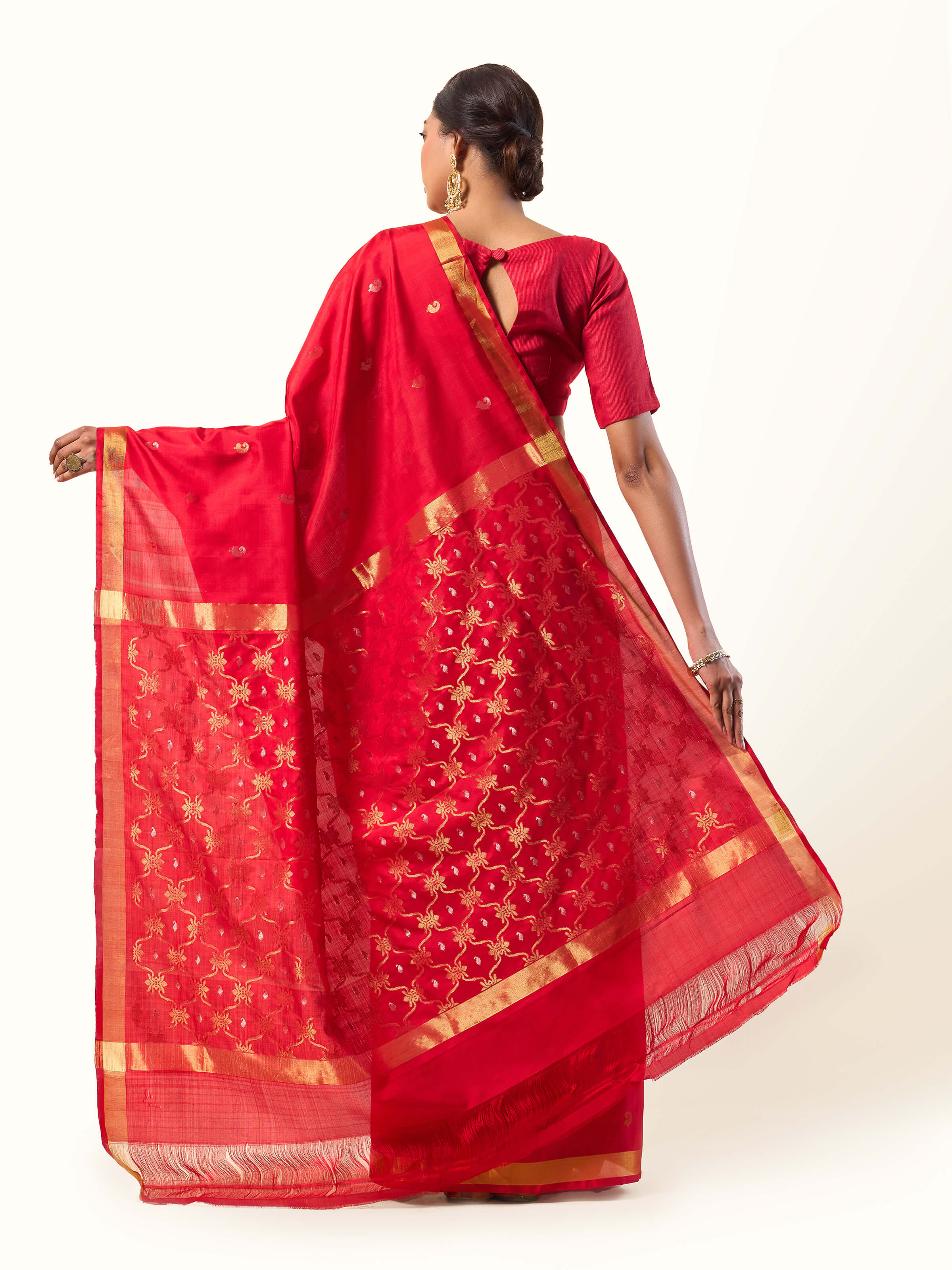 Back view of red Uppada Jamdani saree showcasing classic patterns and pleats.