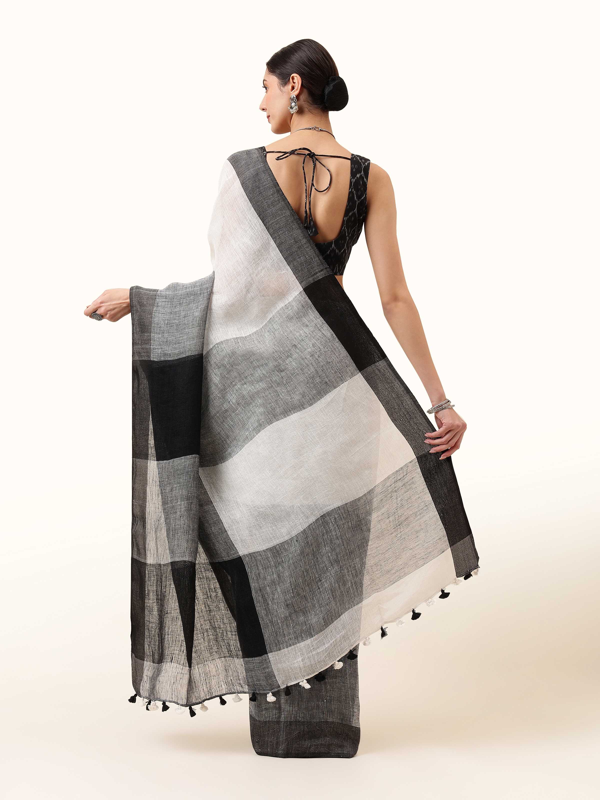 Back view of black linen saree highlighting smooth pleats and graceful fall