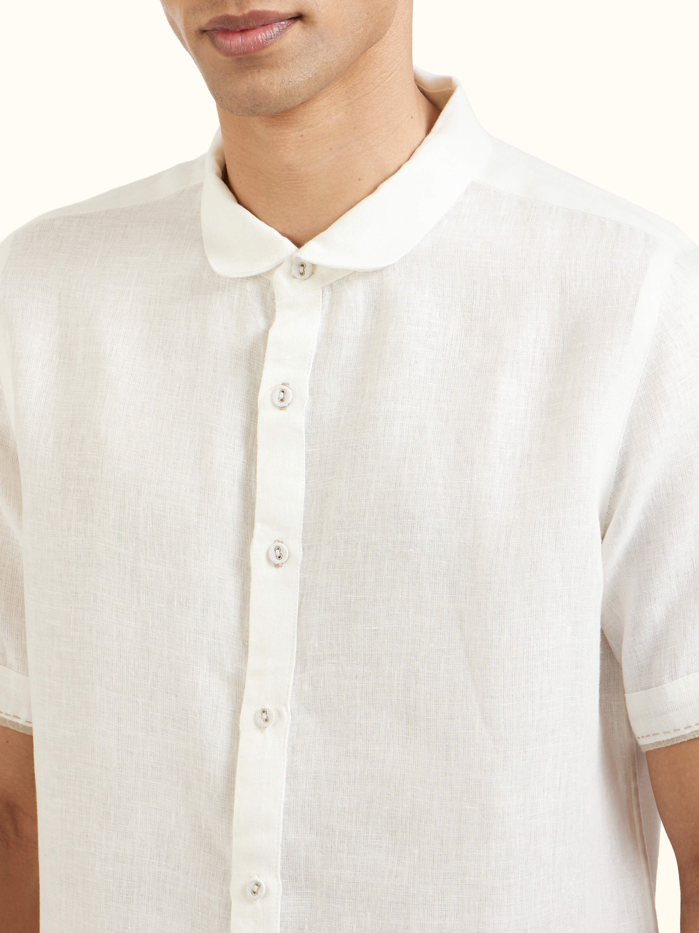Detail view of white Peter Pan collar linen shirt showing fabric texture and stitching