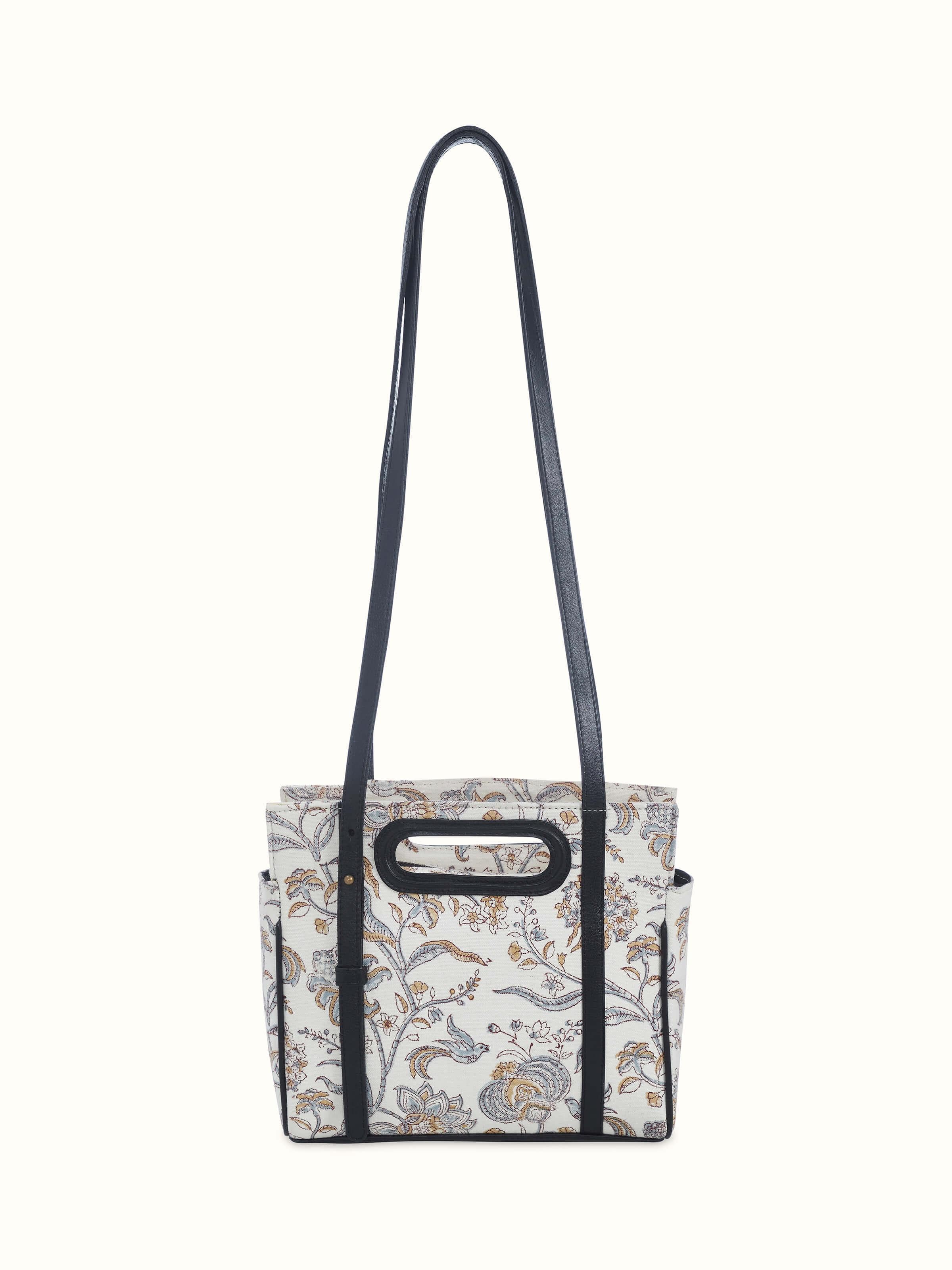 Front view of black leather and textile sling bag with hand block prints.