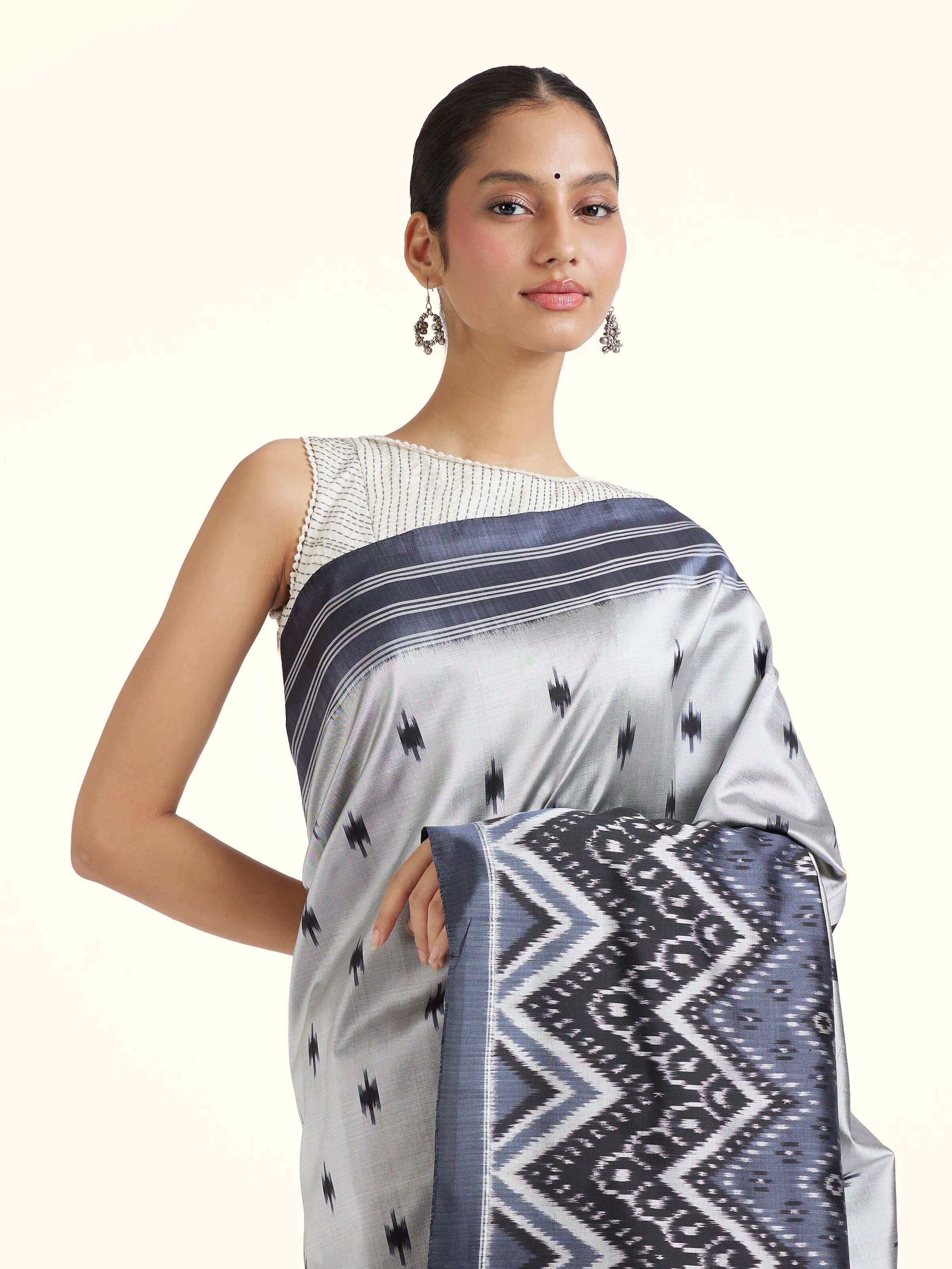 Angled view of off-white mulberry silk ikat saree emphasizing weave and texture