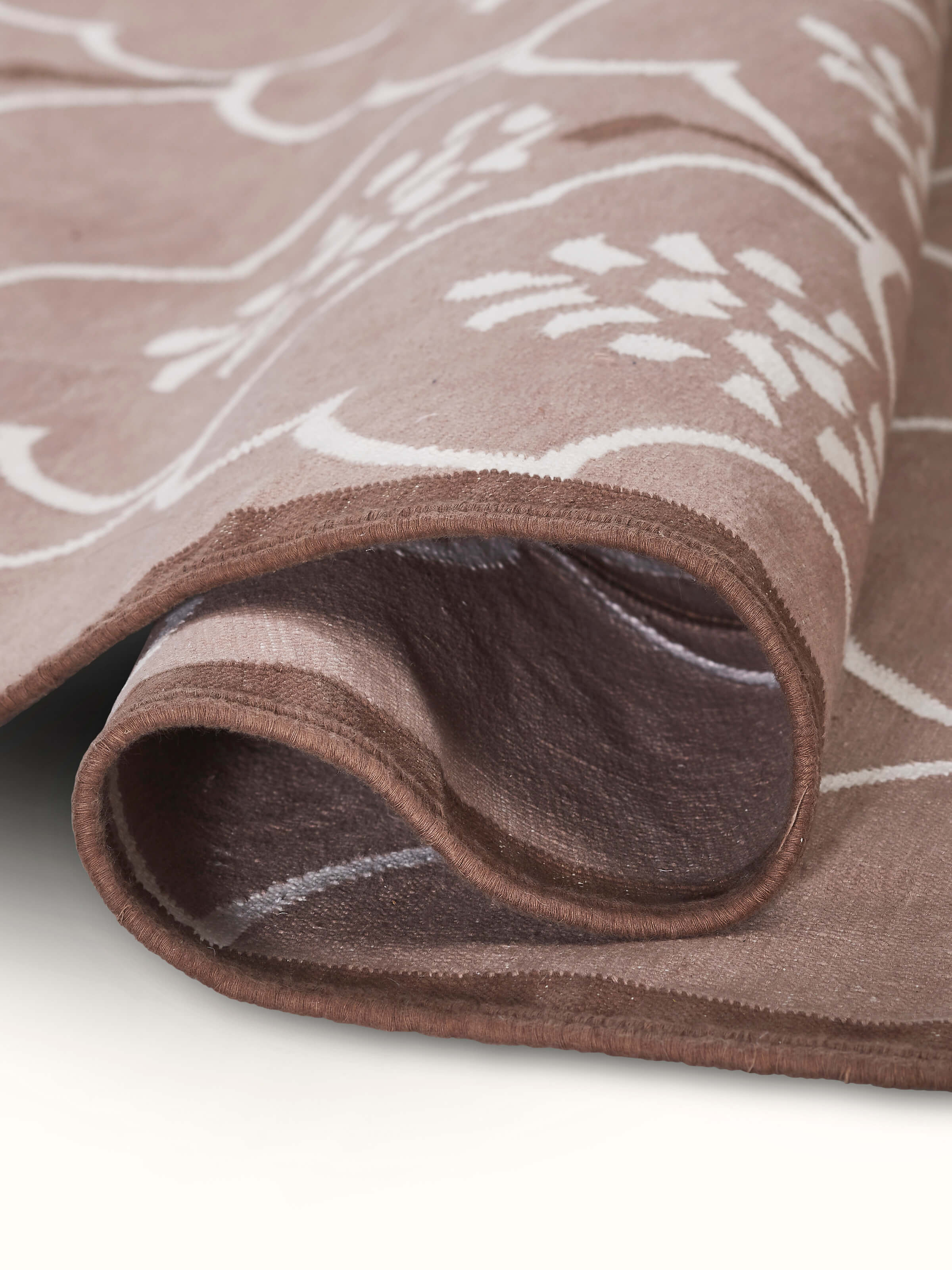 Close-up of Stylised floral beige lawan cotton panja dhurrie demonstrating the quality of the cotton weave