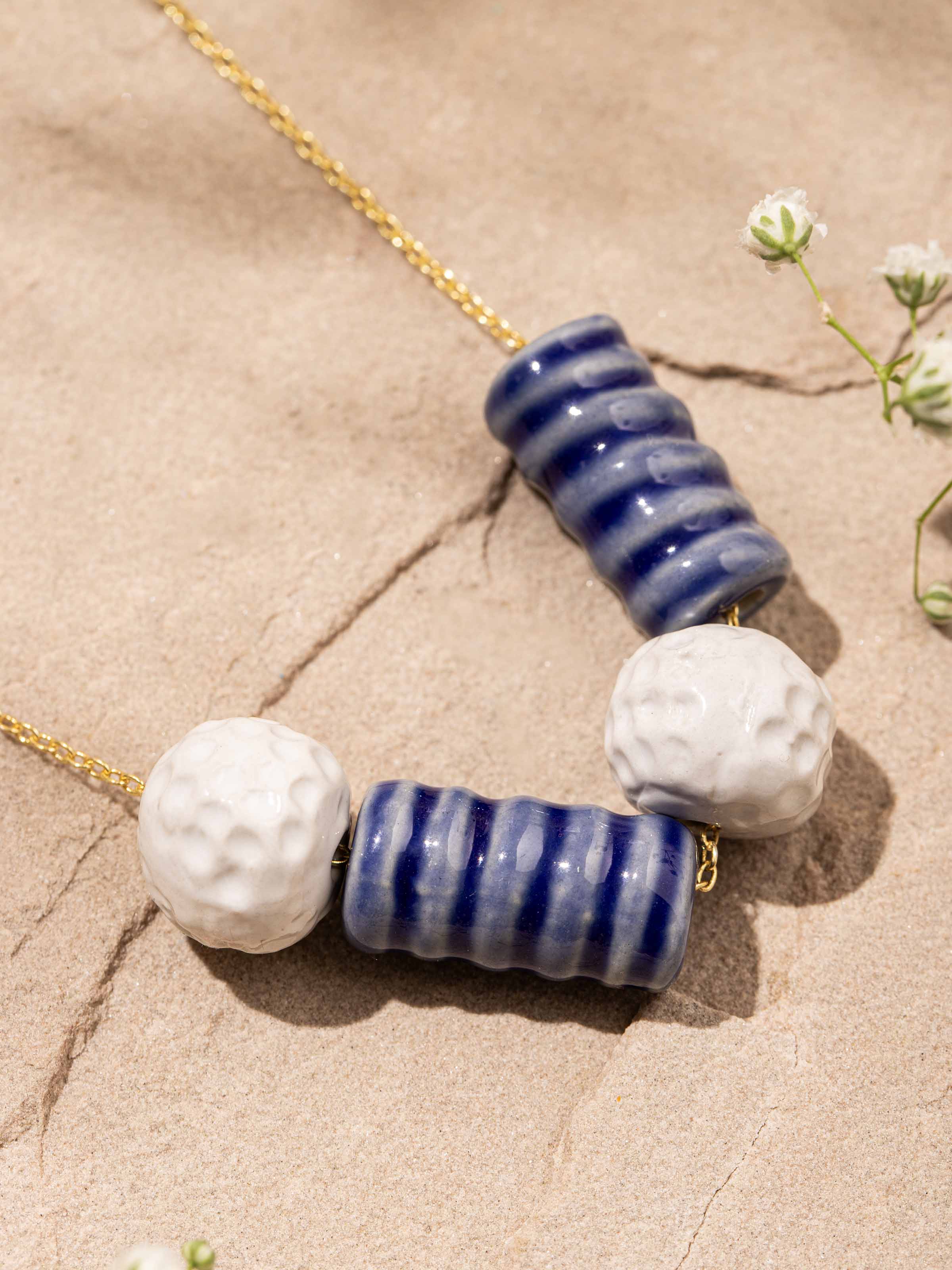 Artistic overhead shot capturing length and craftsmanship of ceramic necklace