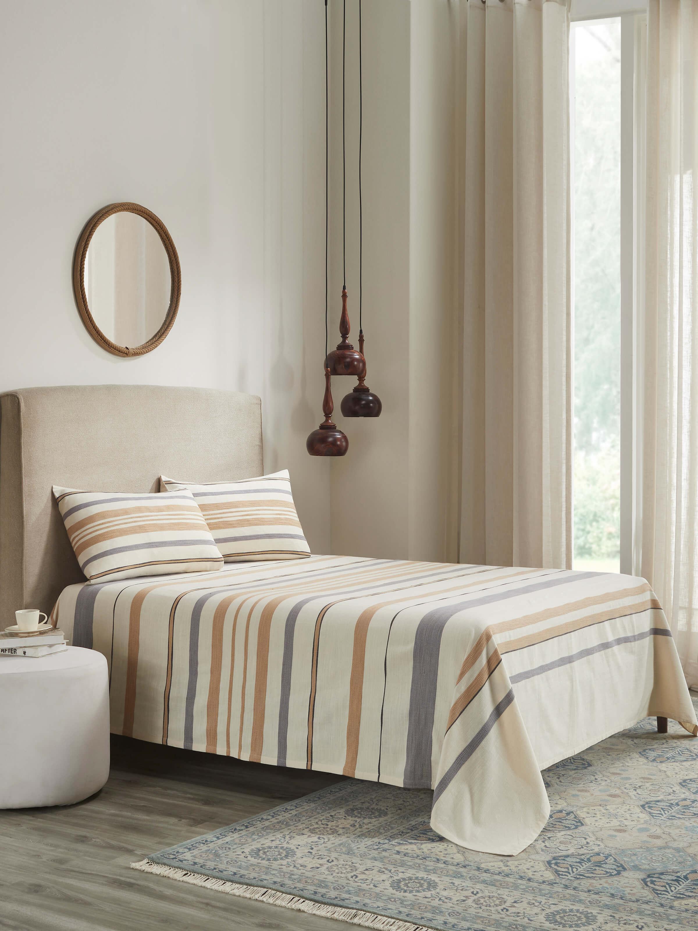 Lifestyle view of Neerja Beige Stripe Cotton Handloom King-size Bedspread Set styled on a bed, exuding minimalist elegance.