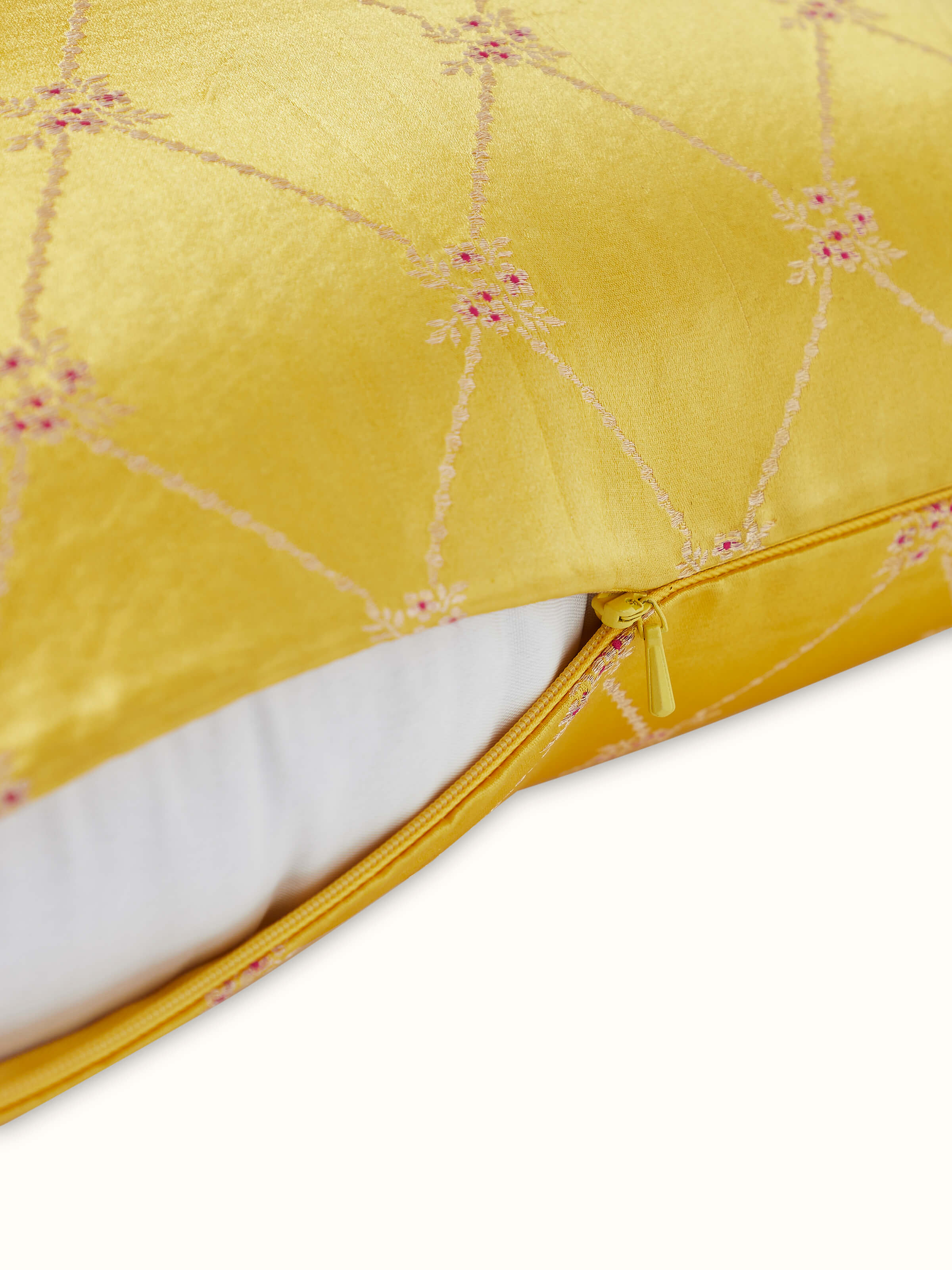 Angled view of Awadh Yellow Banarasi Silk Cushion Cover, focusing on the woven pattern and lustrous silk texture.