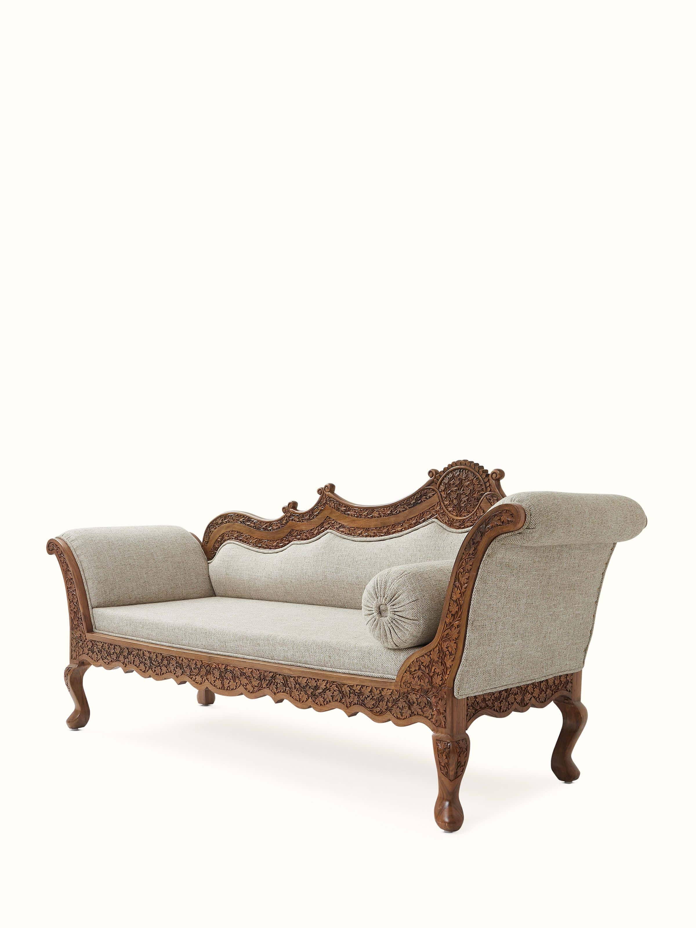 Close-up of the carved walnut wood legs of the handloom fabric upholstered daybed, emphasizing the intricate woodwork
