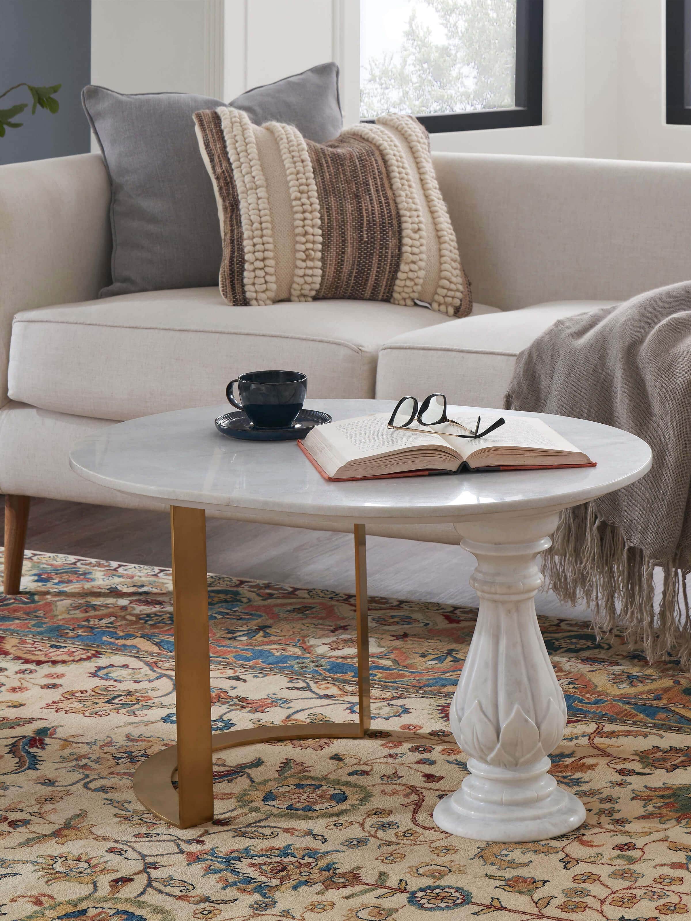 Side view of metal and carved marble top coffee table from Swadesh featuring a stylish metal frame and beautifully carved marble top for a sophisticated look in living spaces.