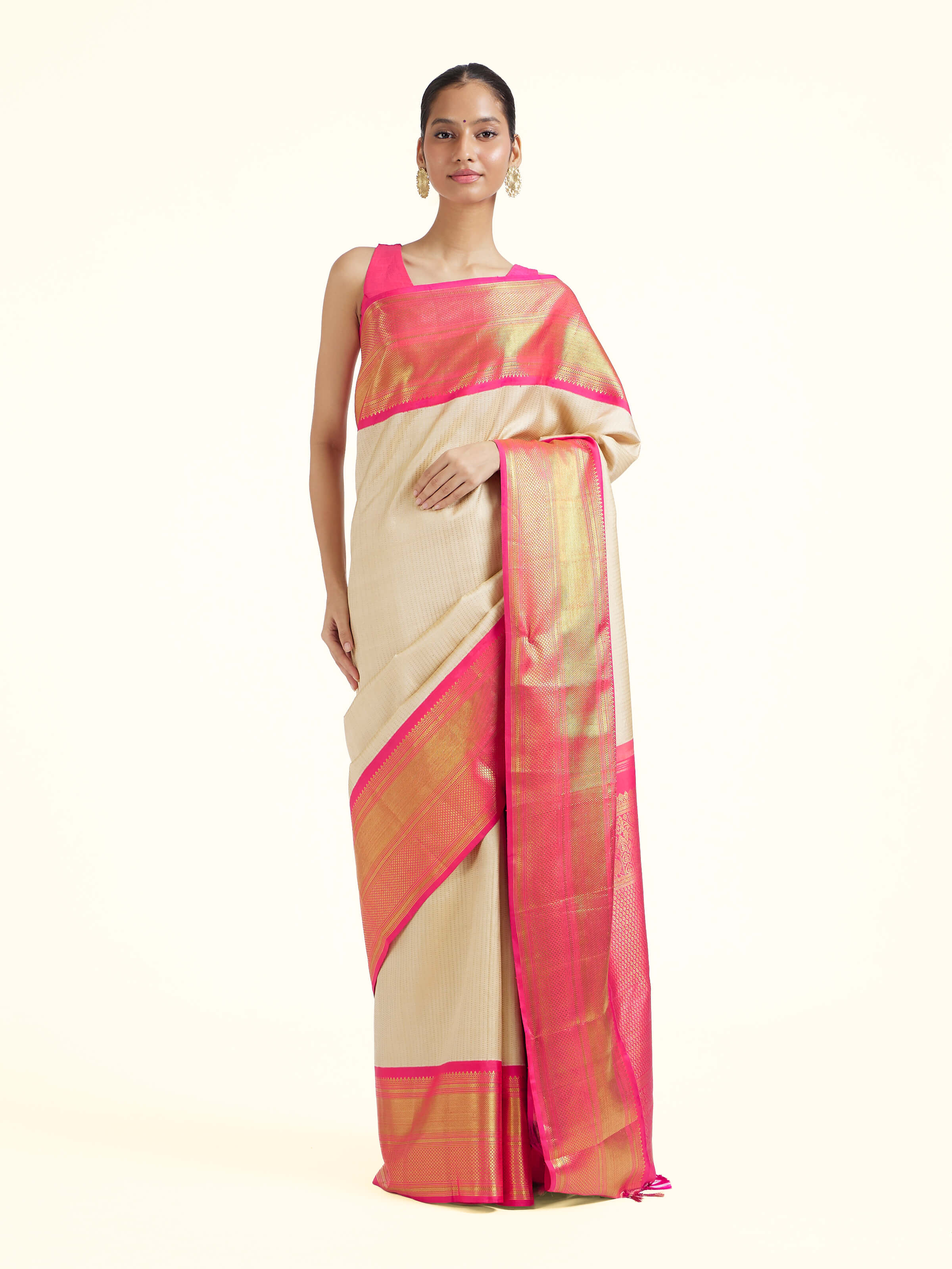Front view of cream silk Kancheepuram saree with rich zari woven motifs