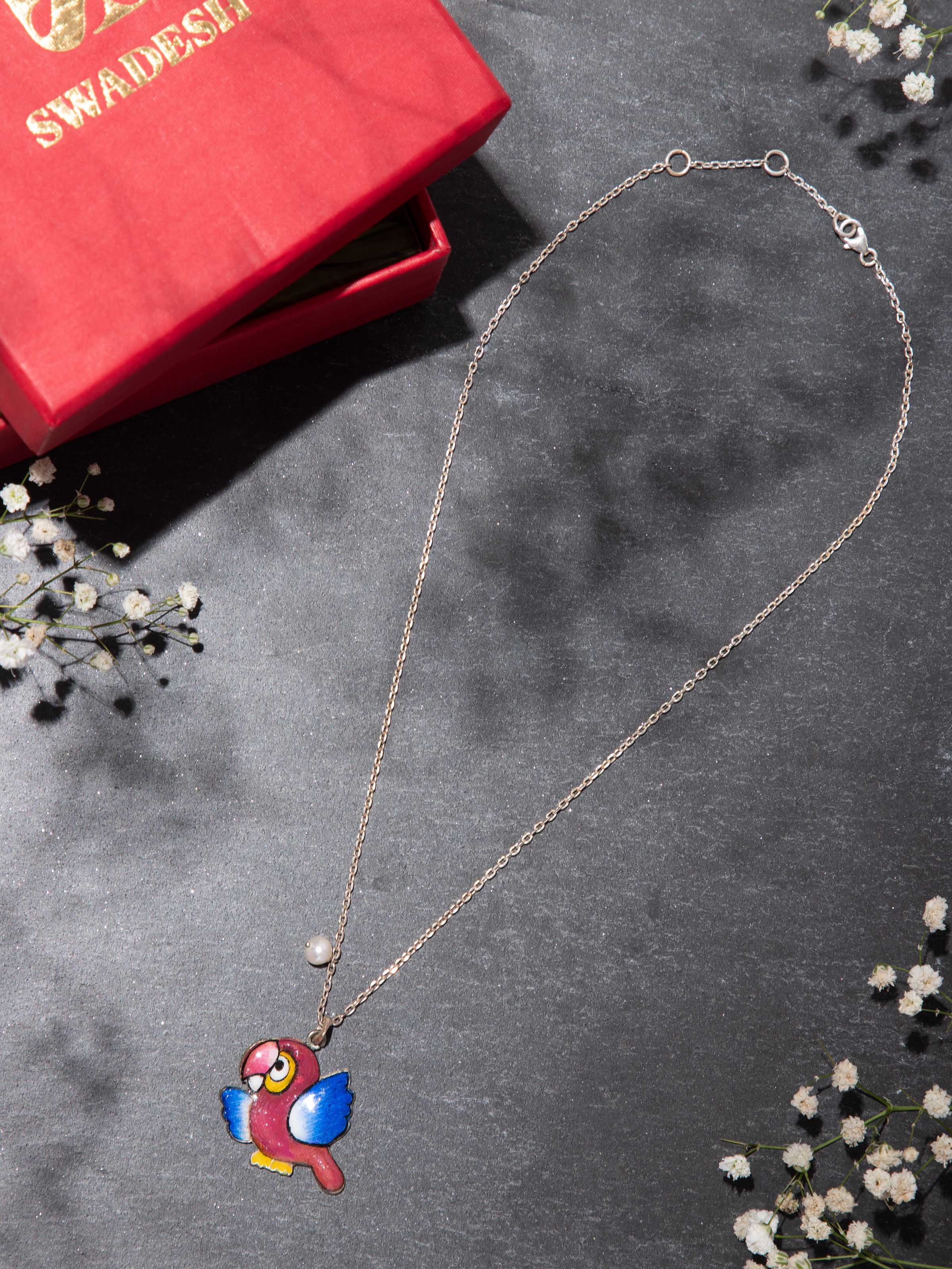 Woman wearing Gulabi Meenakari silver pendant, highlighting its traditional elegance against festive attire.