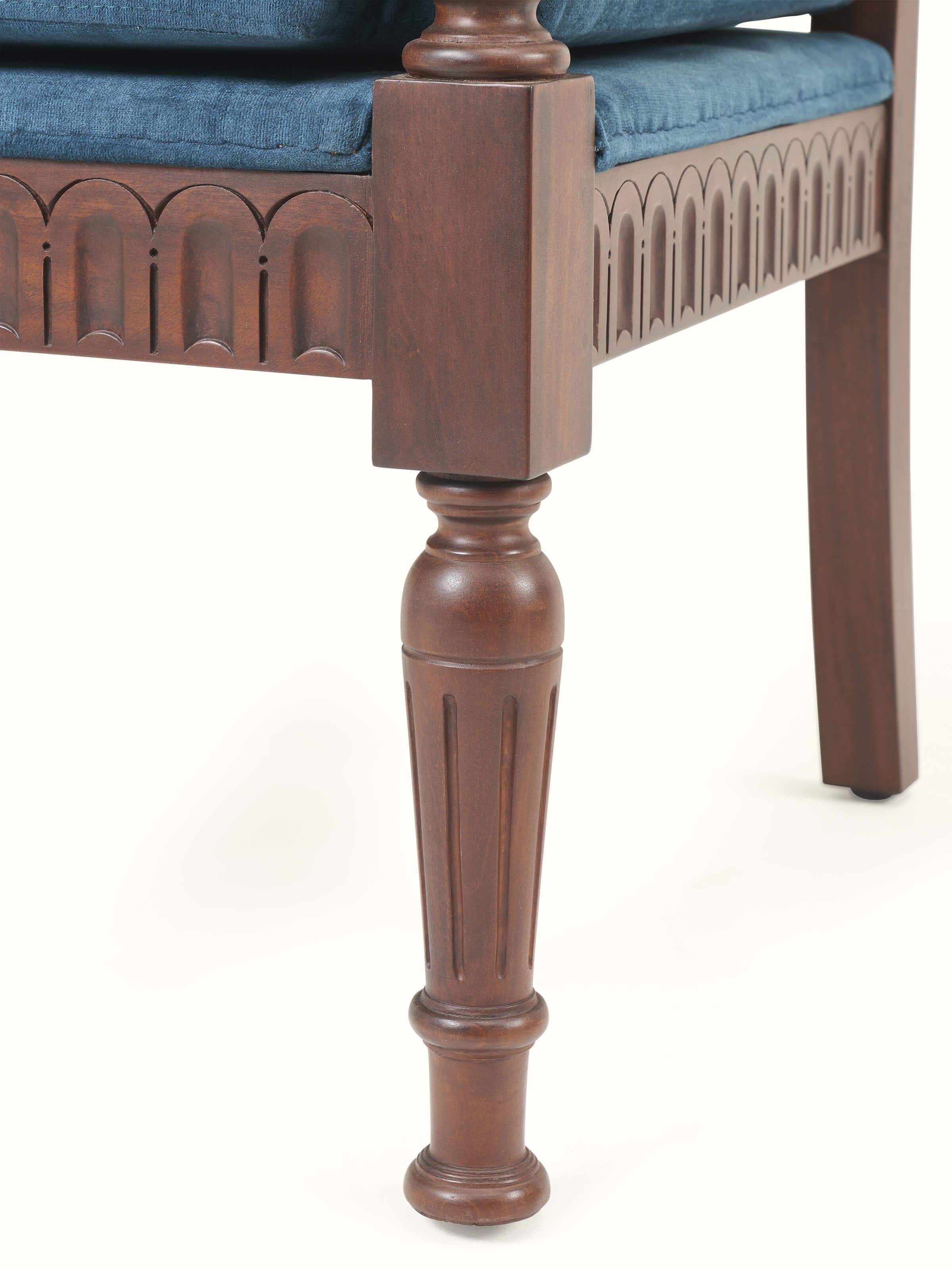 Close-up detail view of wooden armrest and upholstered backrest on mahogany arm chair