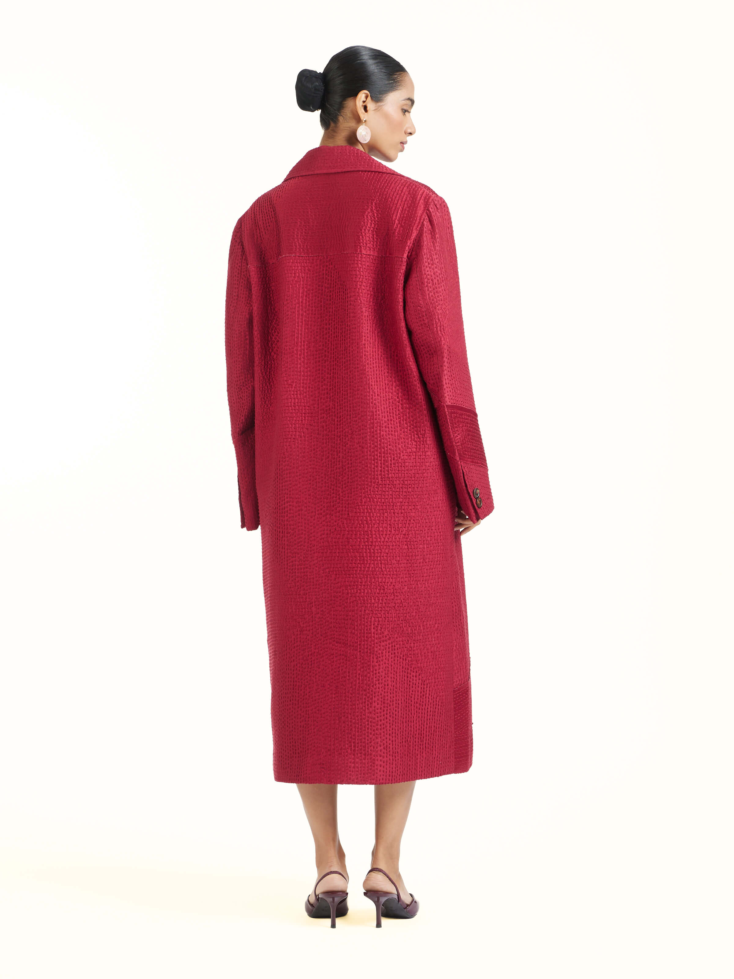 Back view of red silk kantha trench coat displaying overall design and embroidery flow