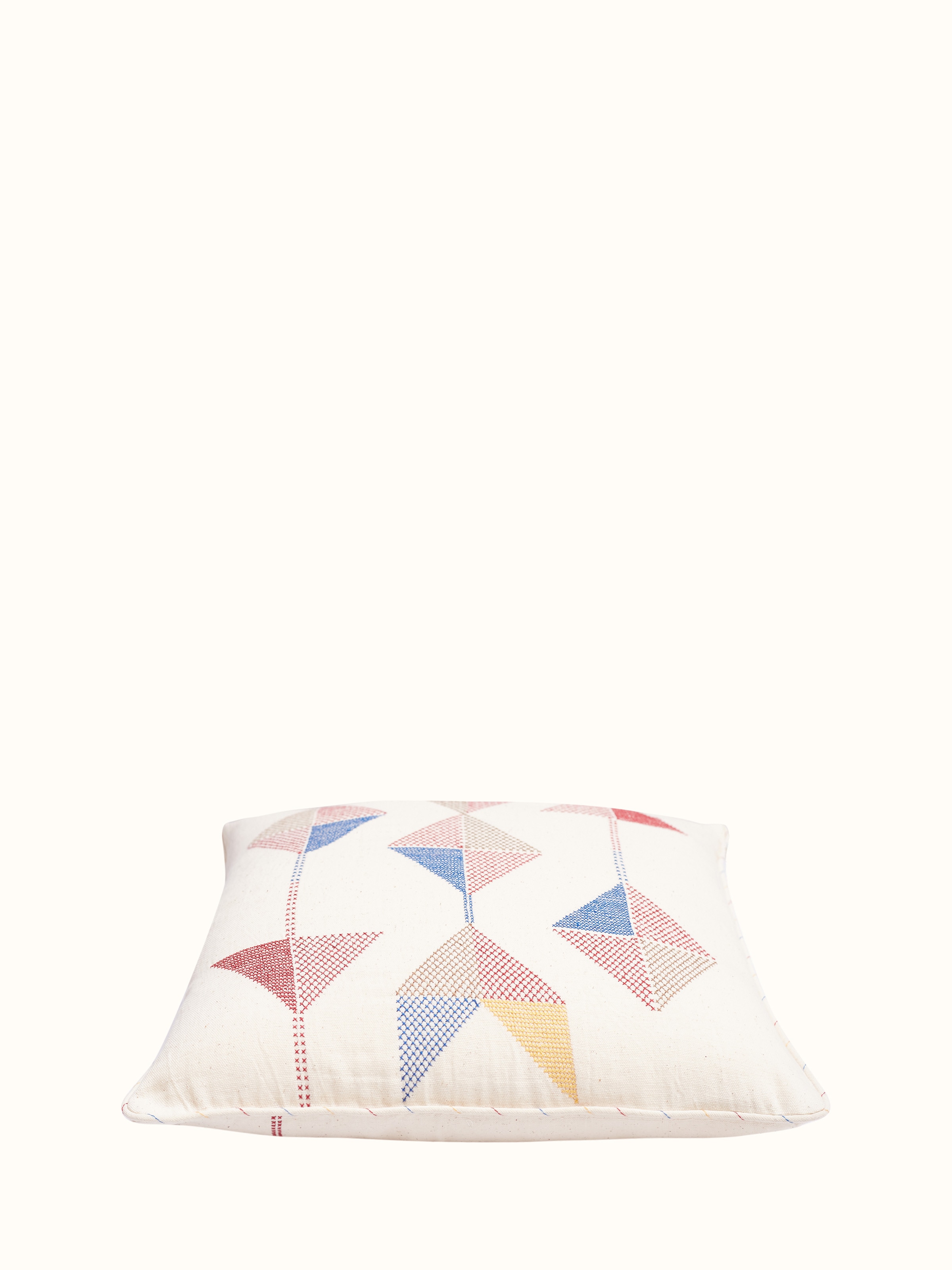 Angled view of Uttarayan hand embroidered cotton cushion cover