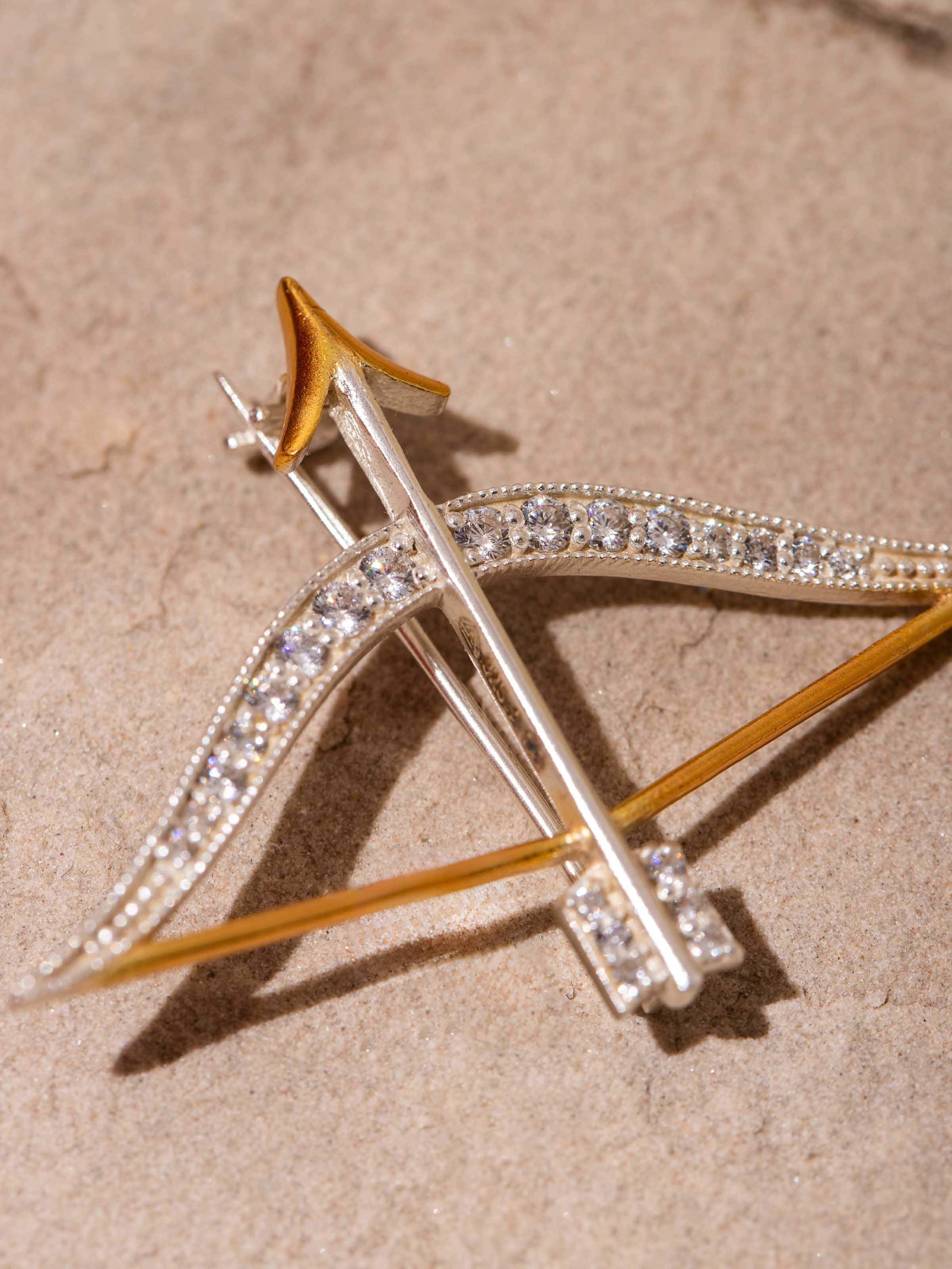 Detail shot showing fine engraving and sculpted pin clasp