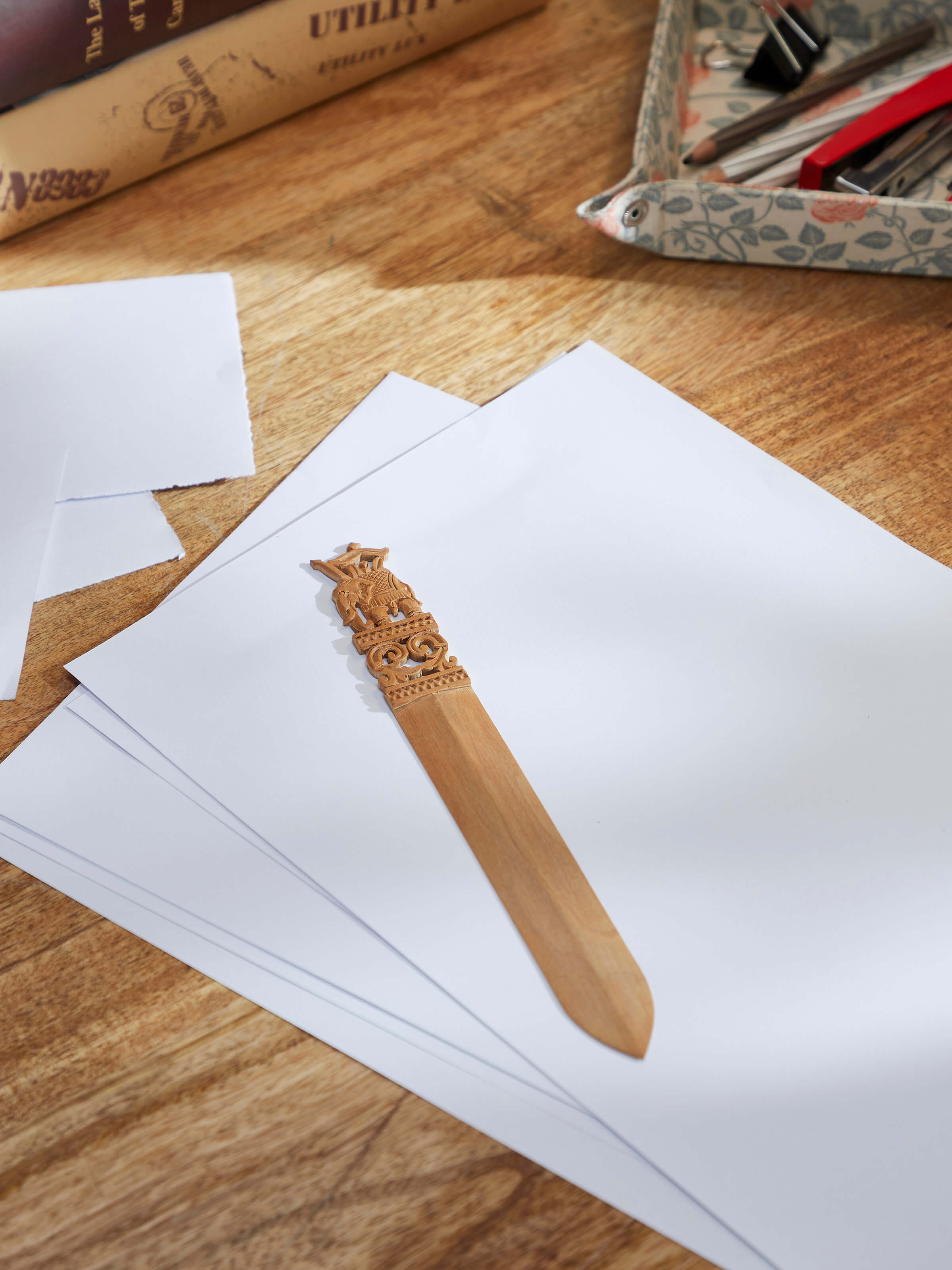 Side view of Carved Sandalwood Paper Cutter from Swadesh highlighting the smooth texture and exquisite detailing