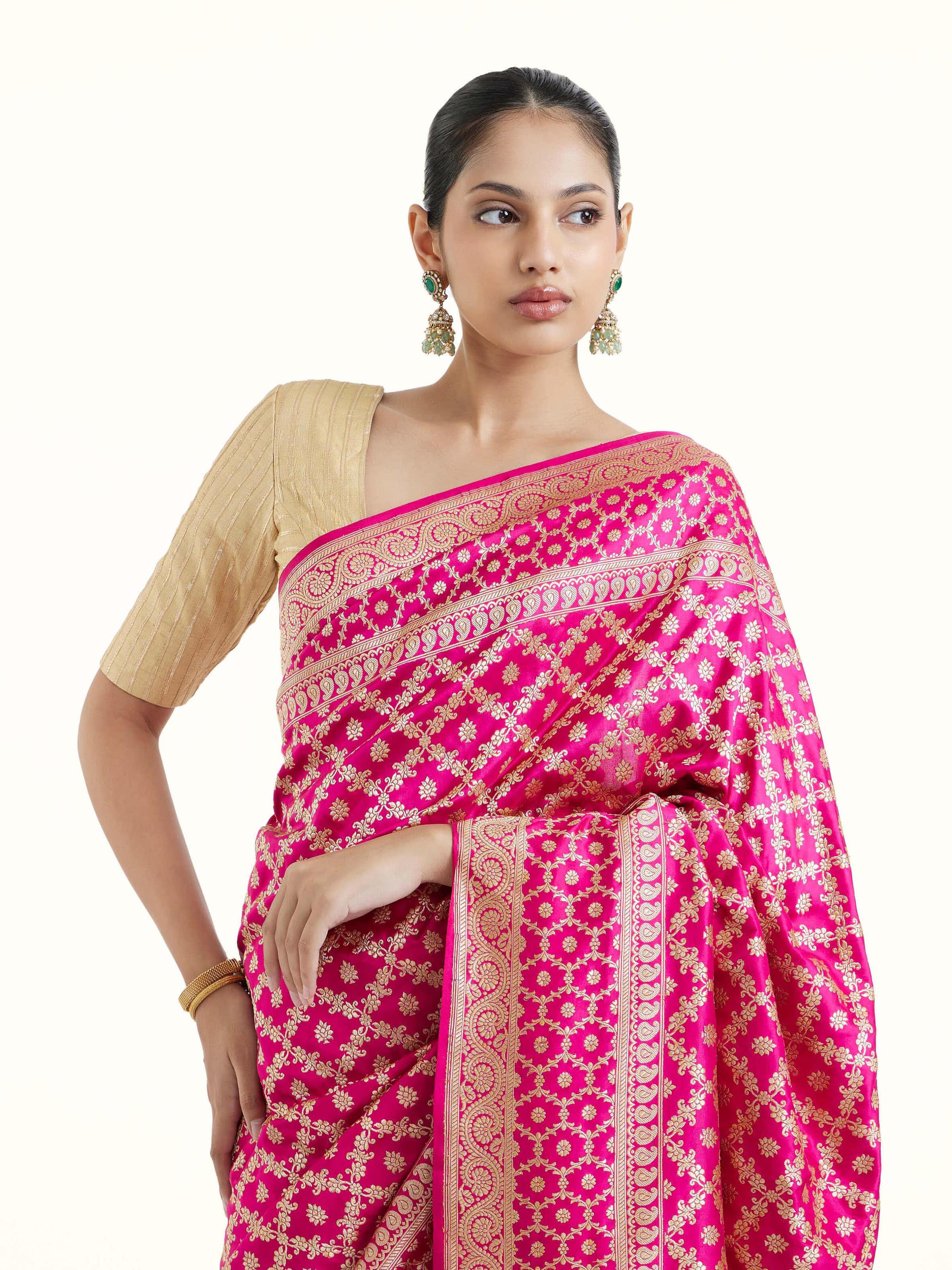 Angled view of fuschia katan silk Banarasi saree highlighting traditional weave