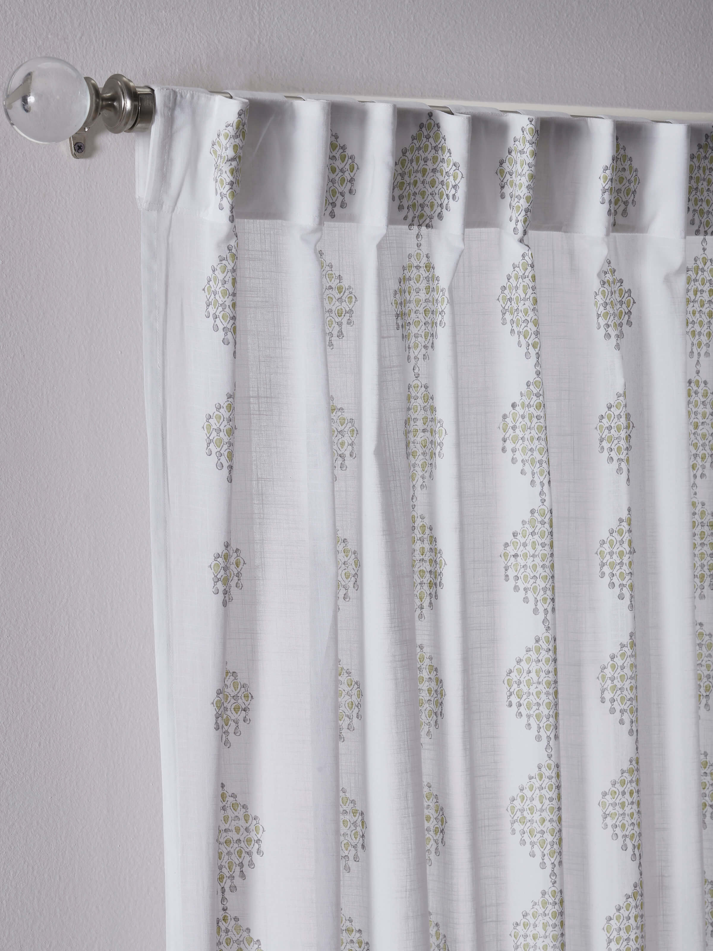 Front view of white cotton curtain with green geometric Sanganeri block print design.