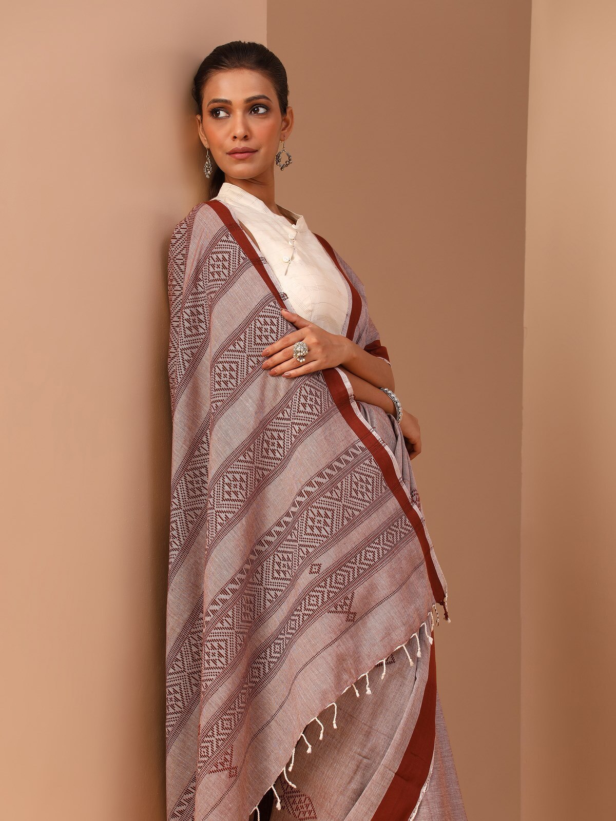 Side lifestyle image of brown cotton saree featuring drape and flow of fabric