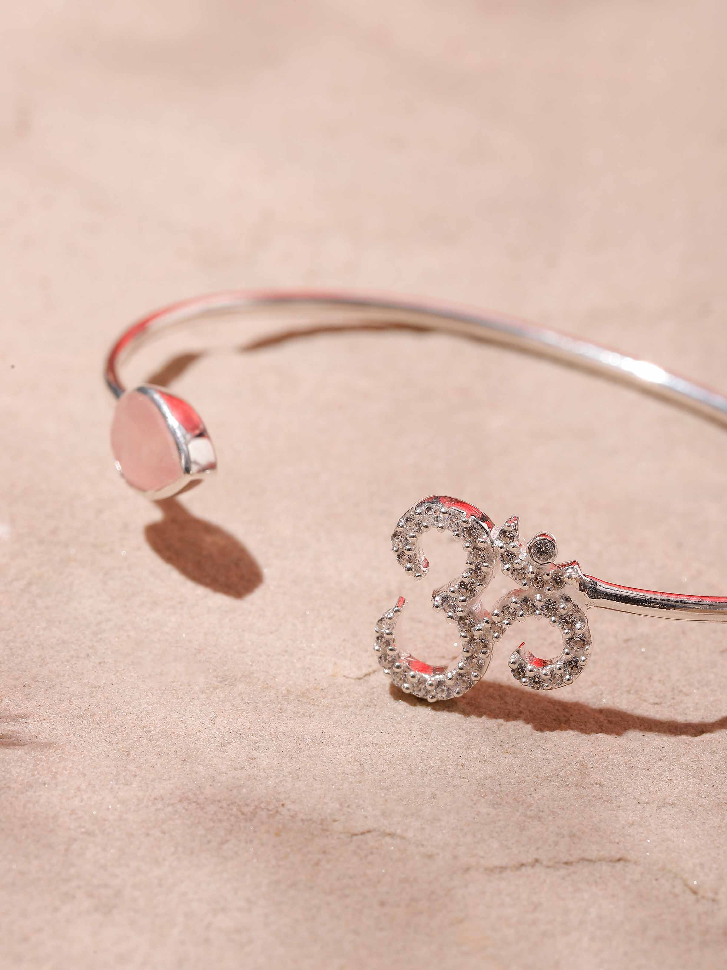 Detailed shot of Rose Quartz & Om Bracelet, focusing on the polished finish and spiritual elements