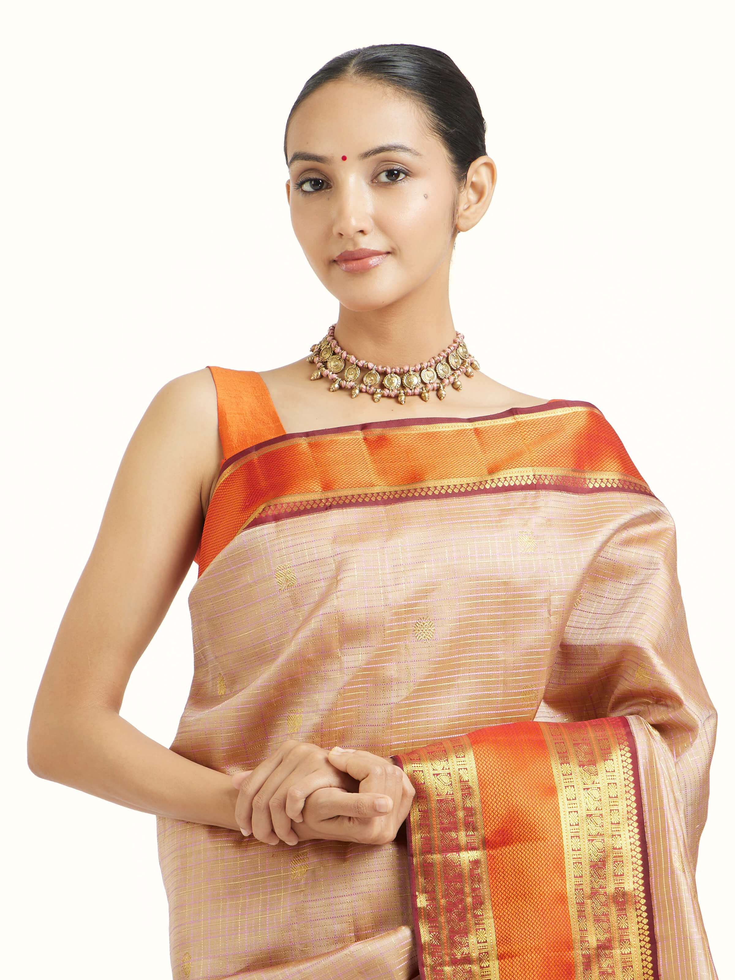 Angled view of biscuit silk Kancheepuram saree highlighting woven motifs