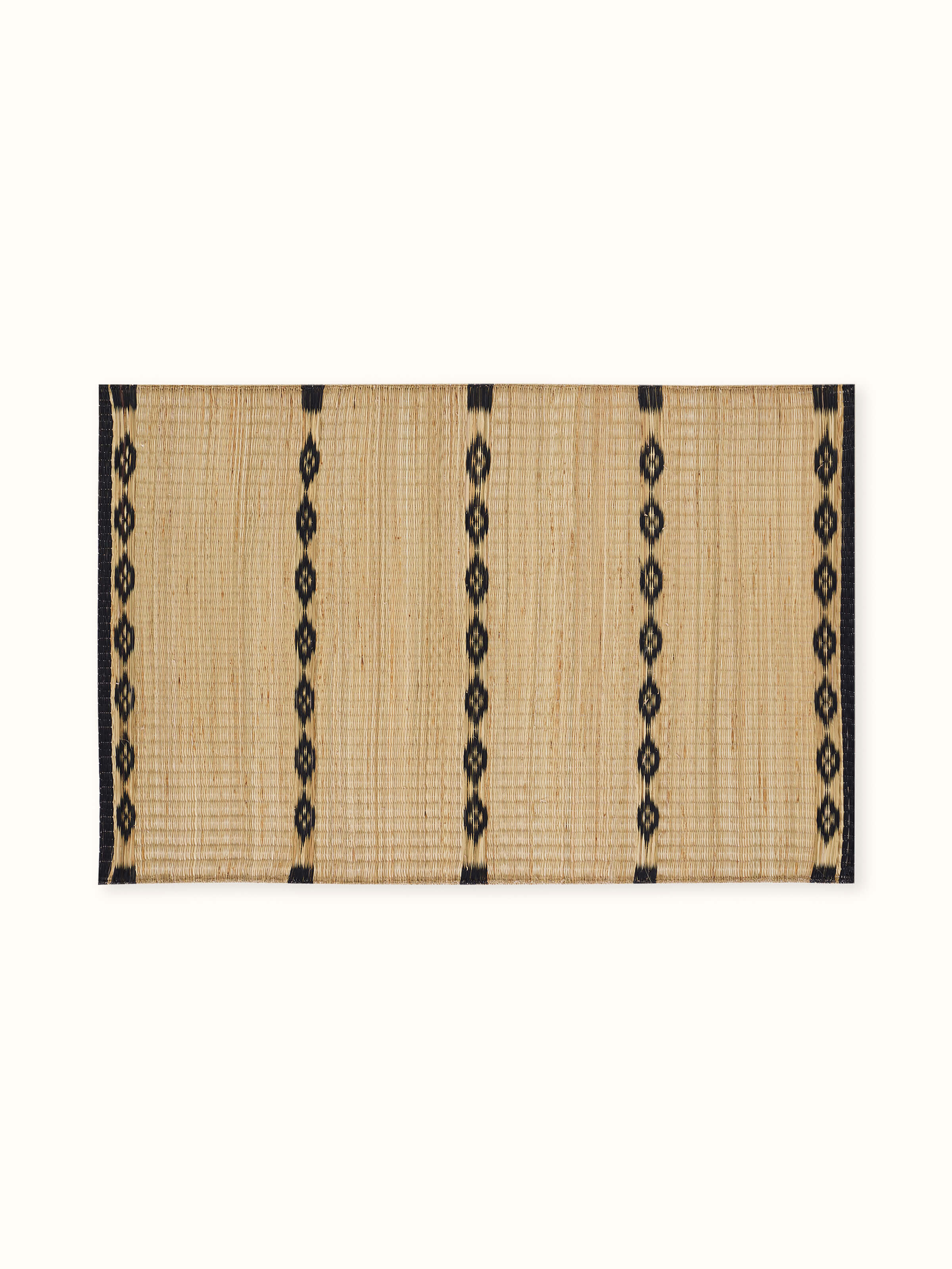 Neatly laid out view of black striped natural Madurkathi table mats from Prakriti