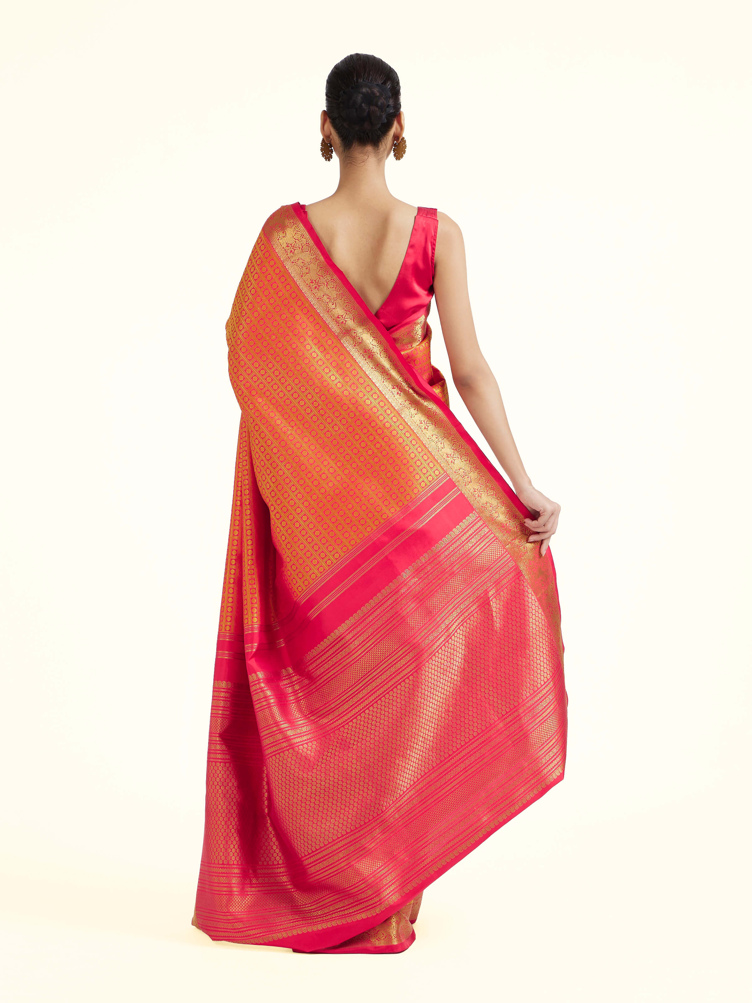 Back view of gold silk Kancheepuram saree displaying elaborate pallu design