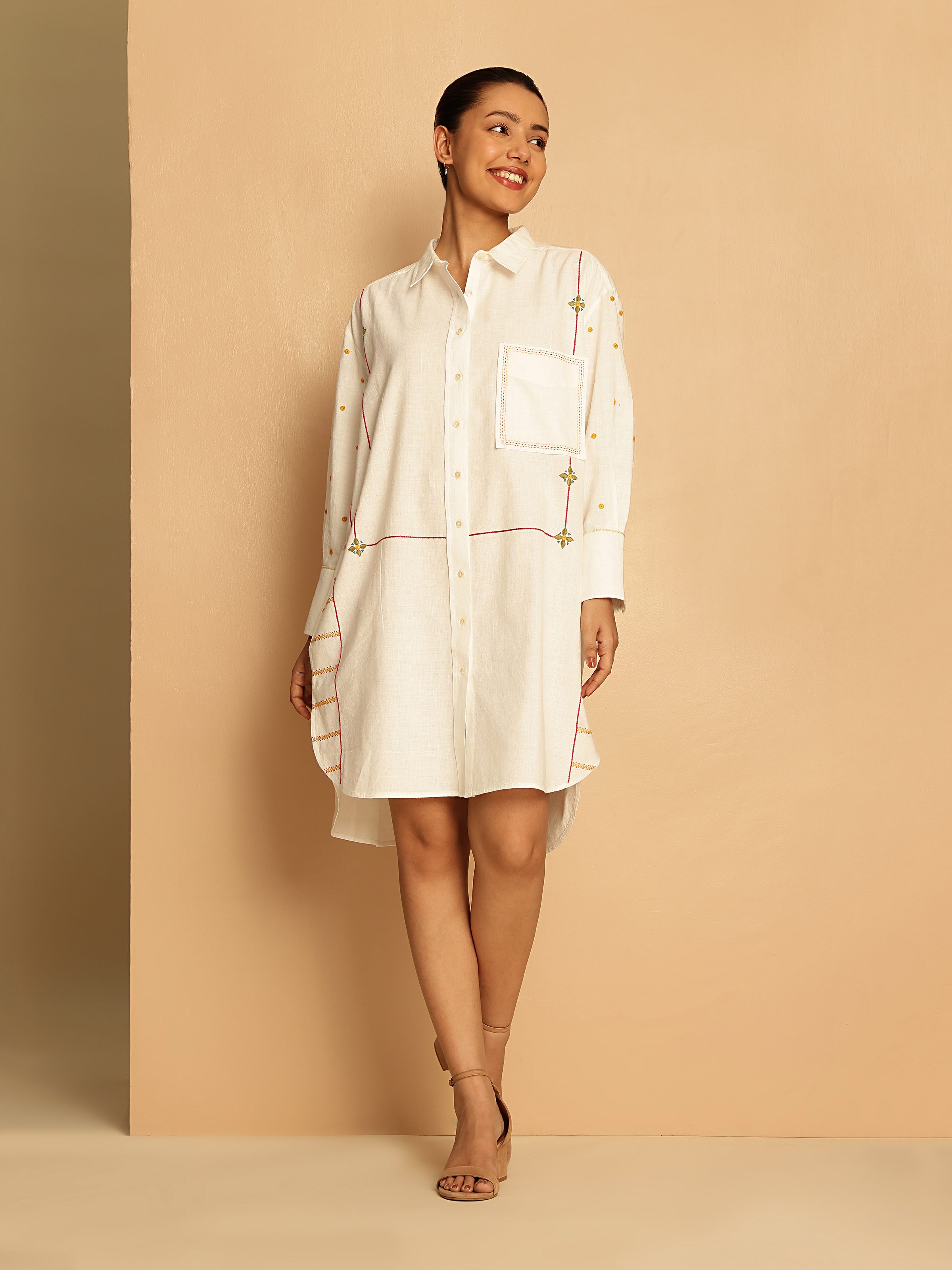 Lifestyle view of off-white embroidered shirt styled with pants, showing intricate detailing.