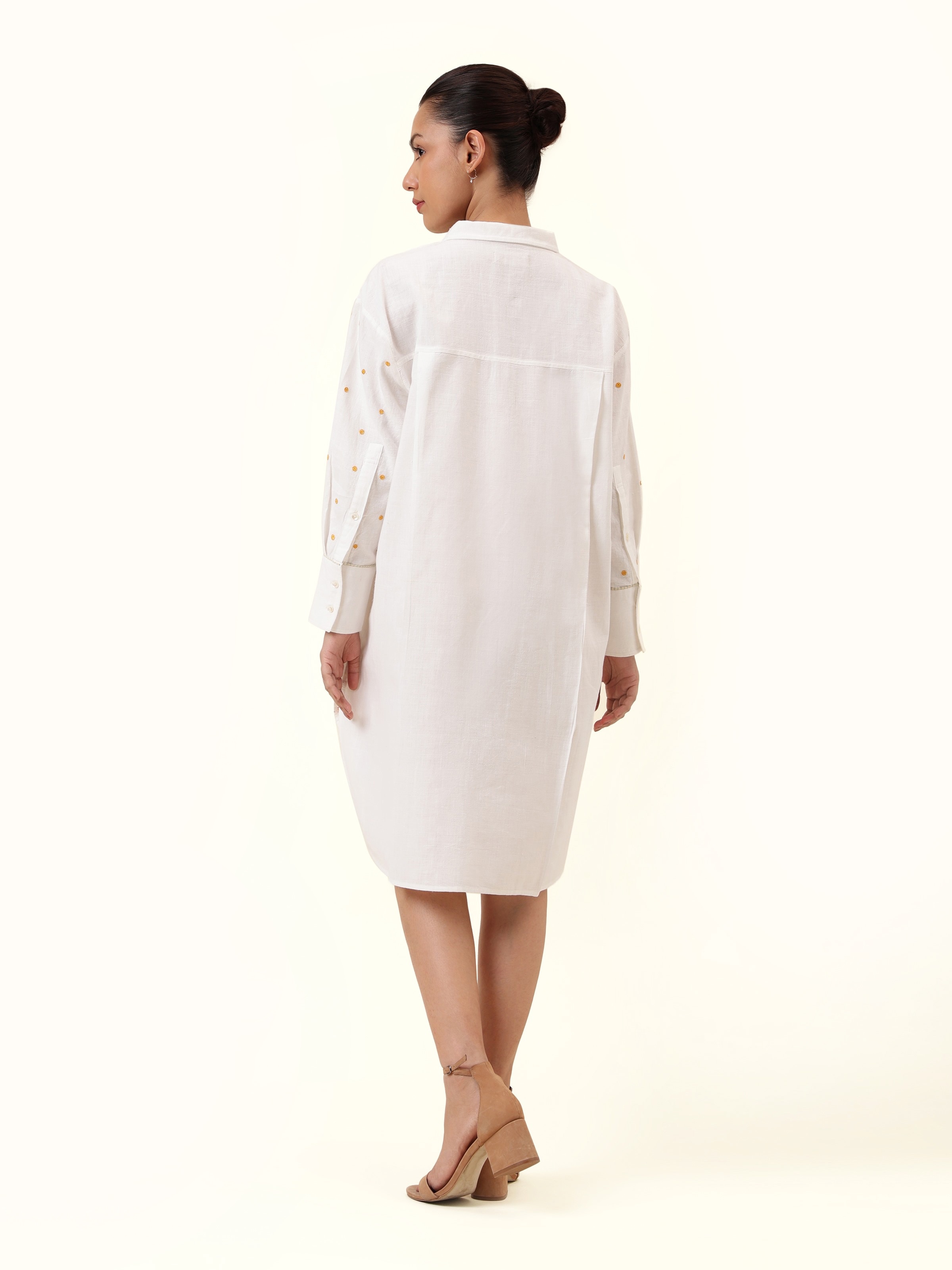 Back view of off-white cotton embroidered shirt displaying clean back and light structure.
