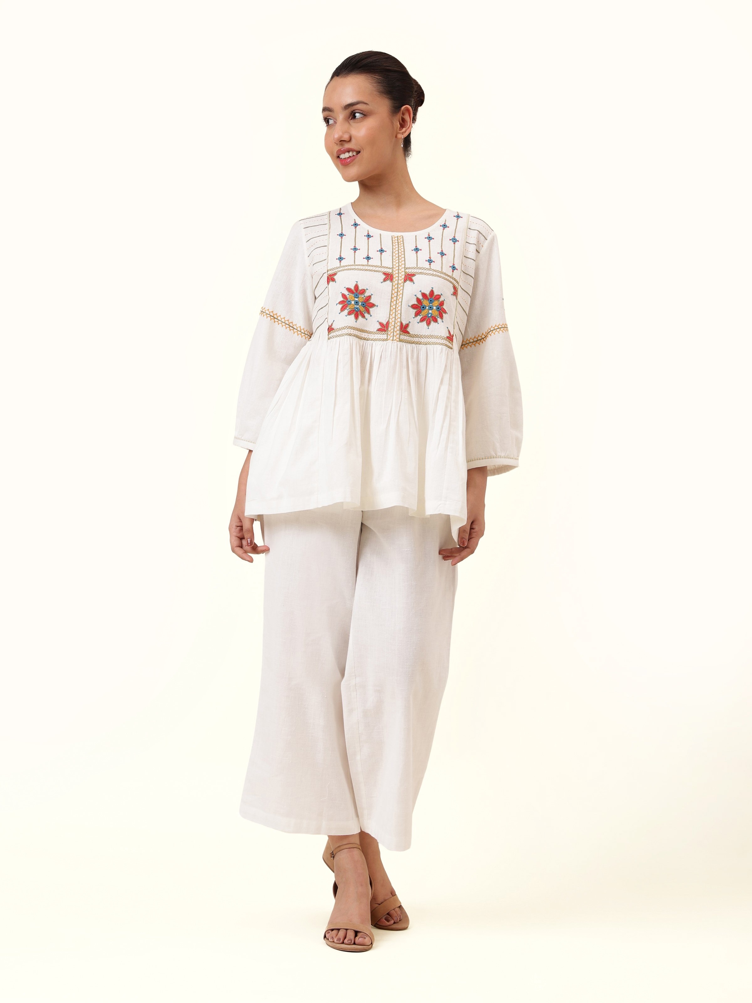 Front view of off-white top with vibrant Pakko Rajasthani embroidered yoke.