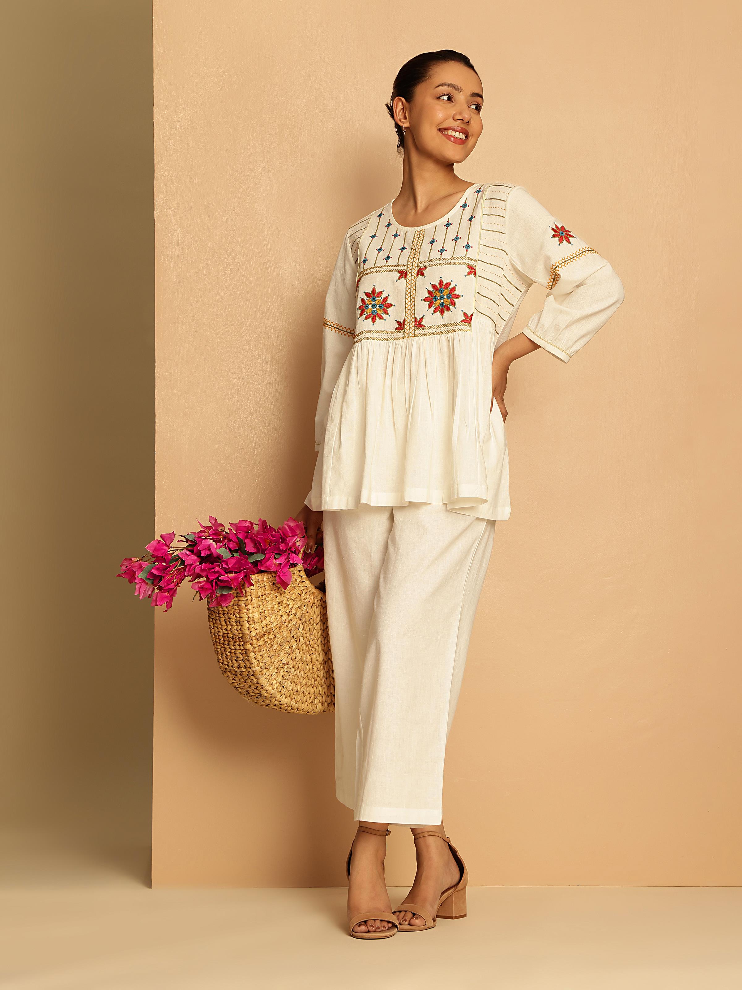 Lifestyle view showing the top paired with printed skirt and silver jewelry.