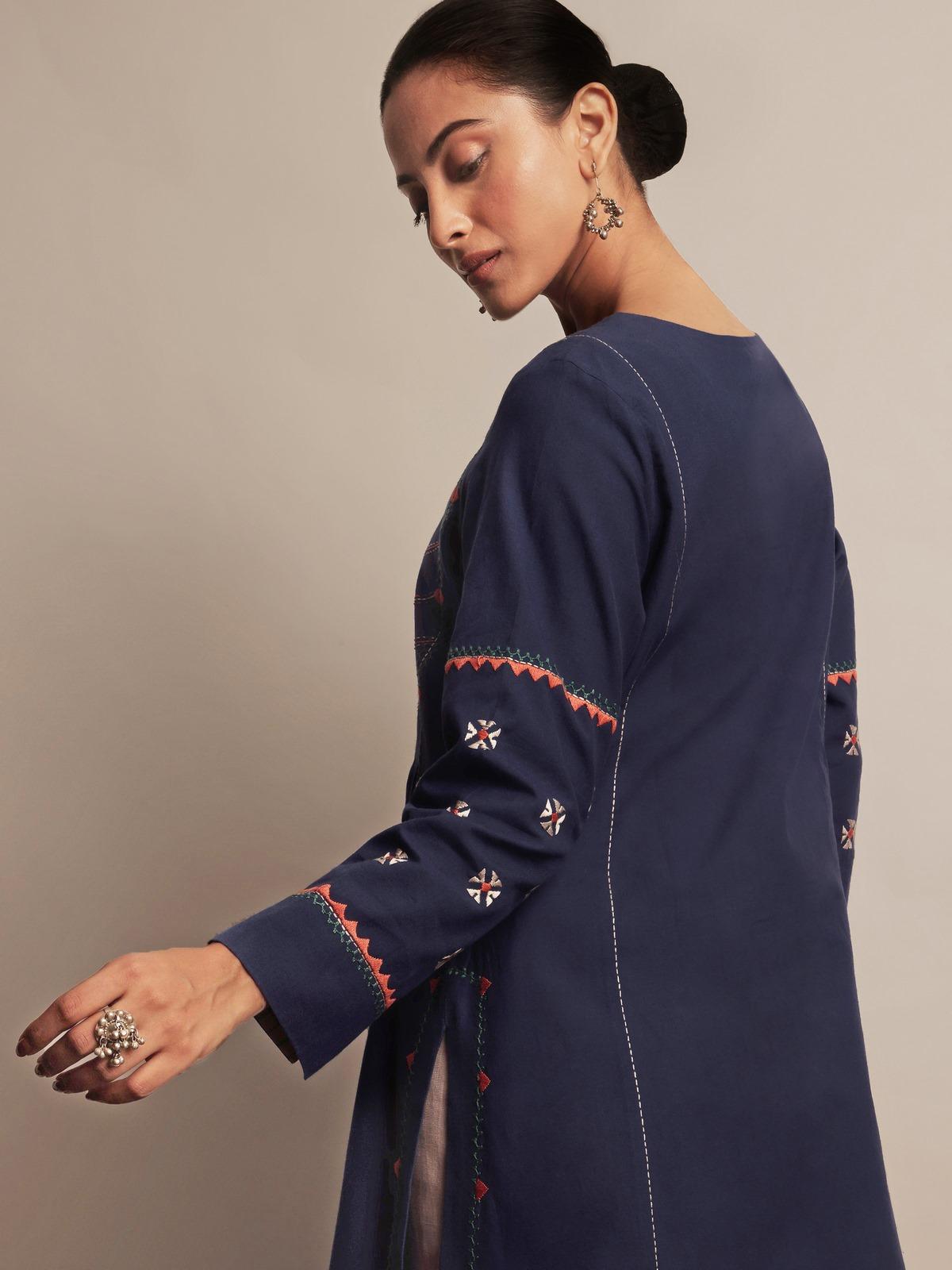Angled lifestyle view showcasing front embroidery and sleeve detailing of indigo cotton kurta