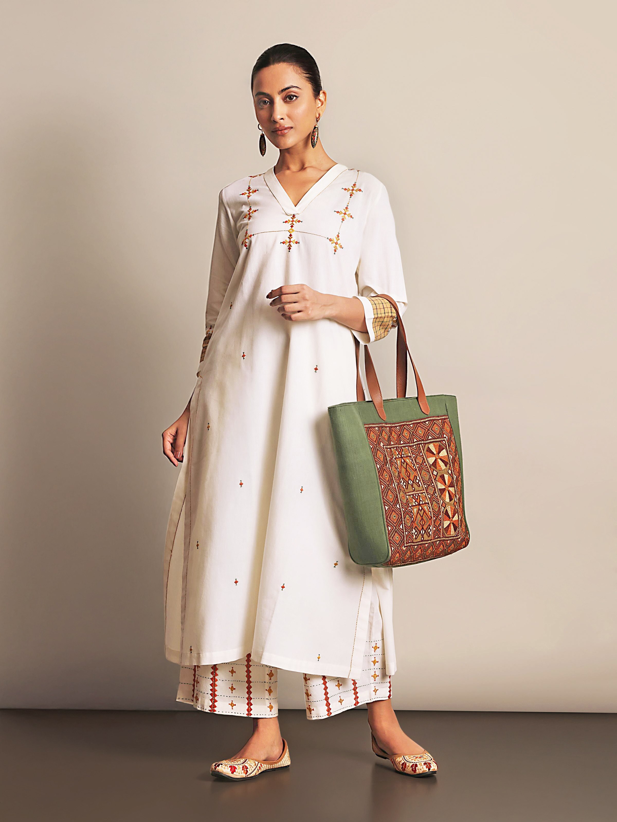 Lifestyle view of Off-white Cotton Rajasthan Embroidery Long Kurta paired with traditional accessories.