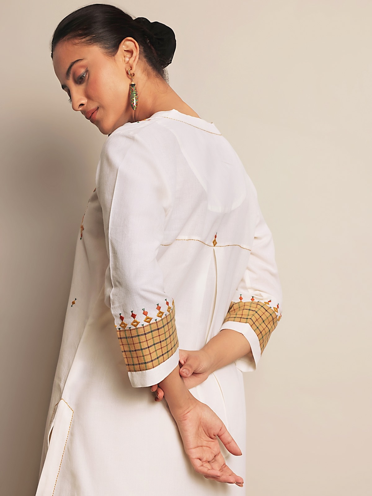 Angled view highlighting embroidery details on sleeves and neckline.