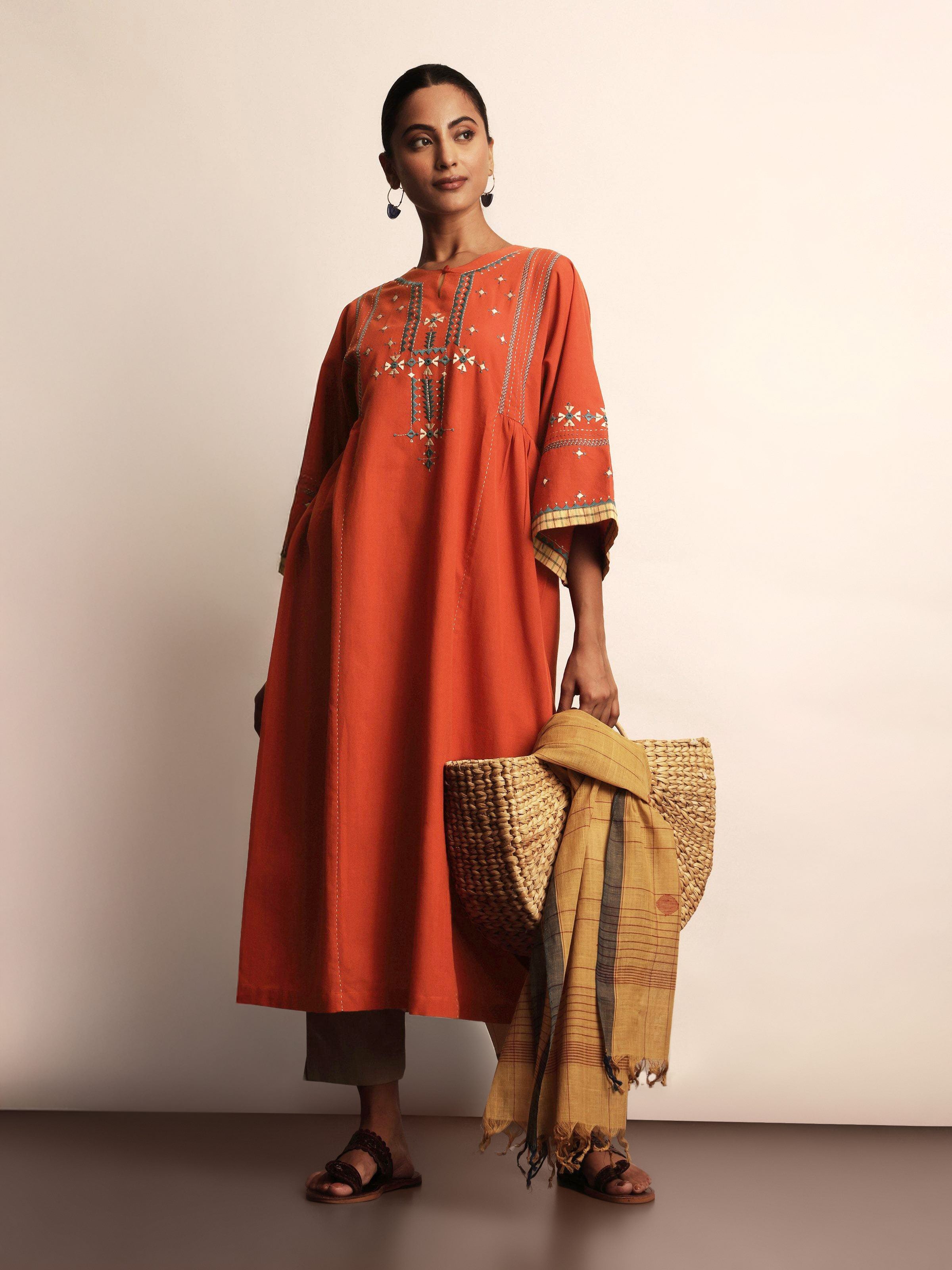 Lifestyle view of rust Rajasthani kurta styled with white pants and oxidized jewelry