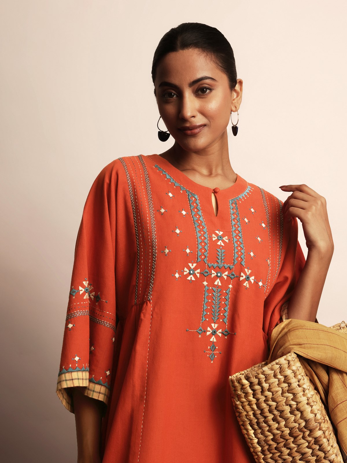 Side lifestyle view highlighting detailed embroidery on rust cotton kurta
