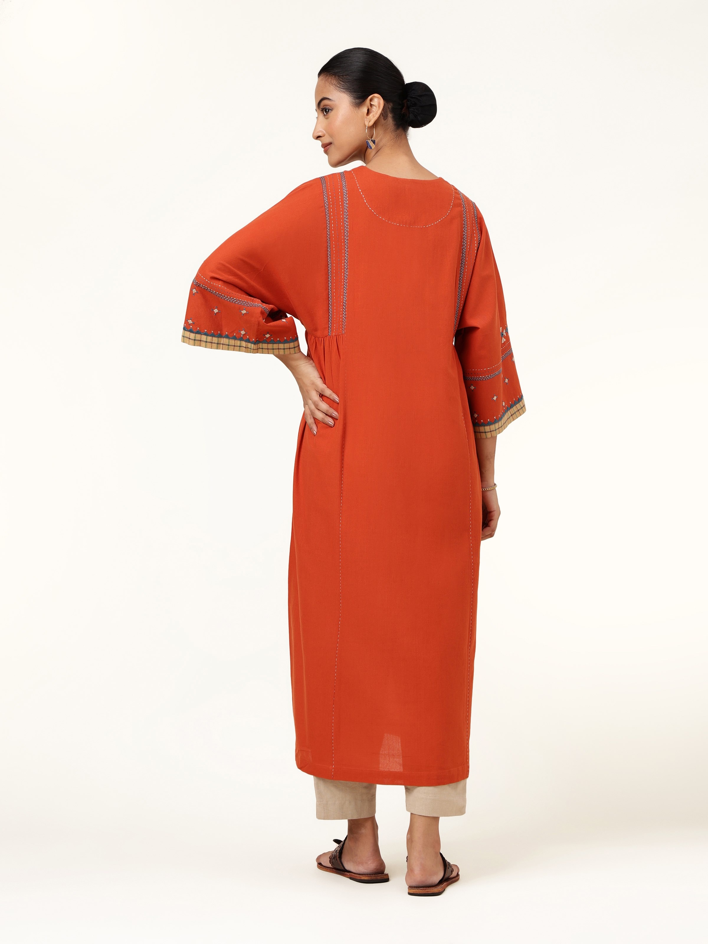 Back view of rust cotton kurta showcasing plain back and long hemline
