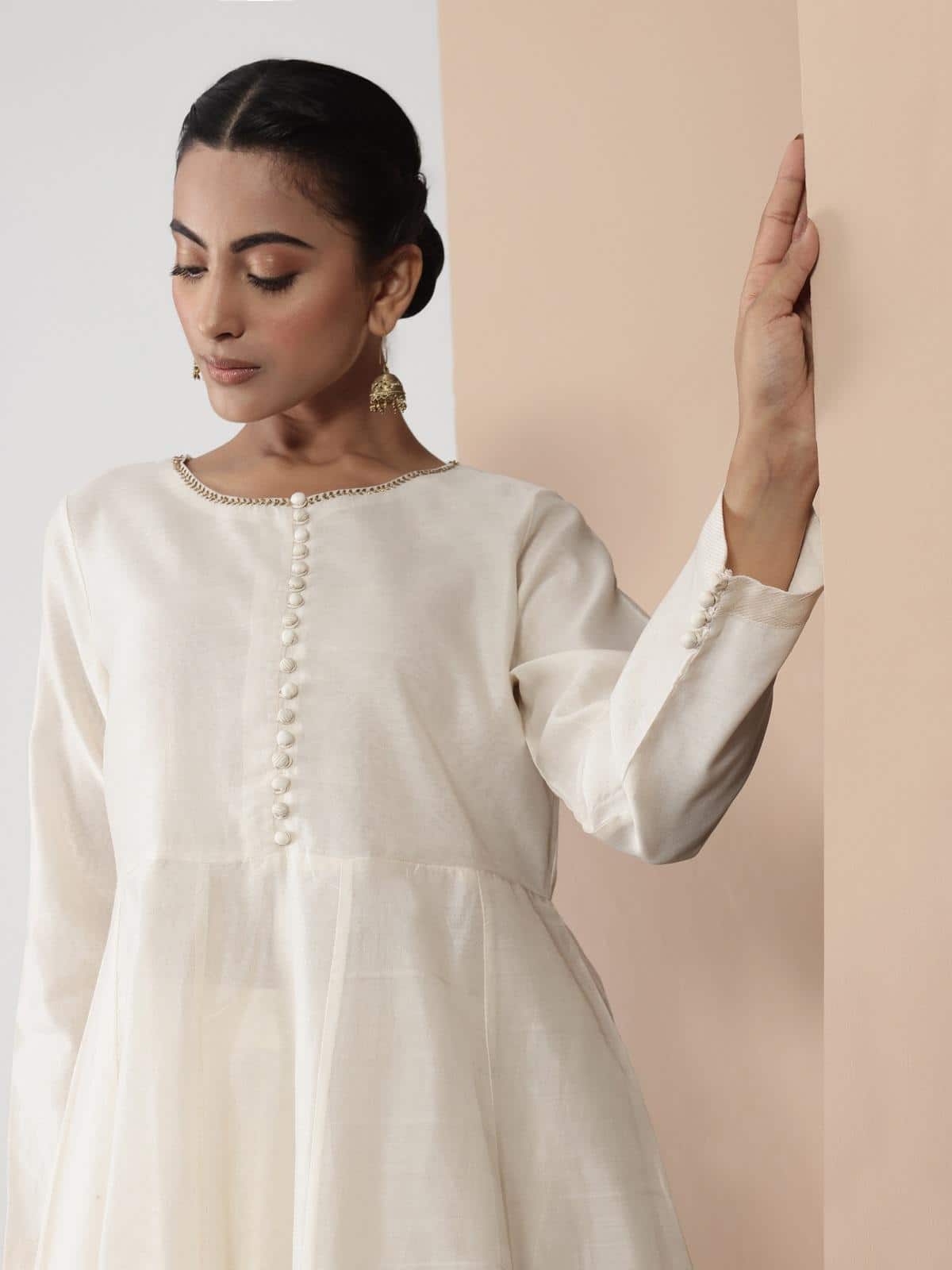 Close-up view of model posing in off-white Anarkali Chanderi kurta with fine detailing and traditional charm.