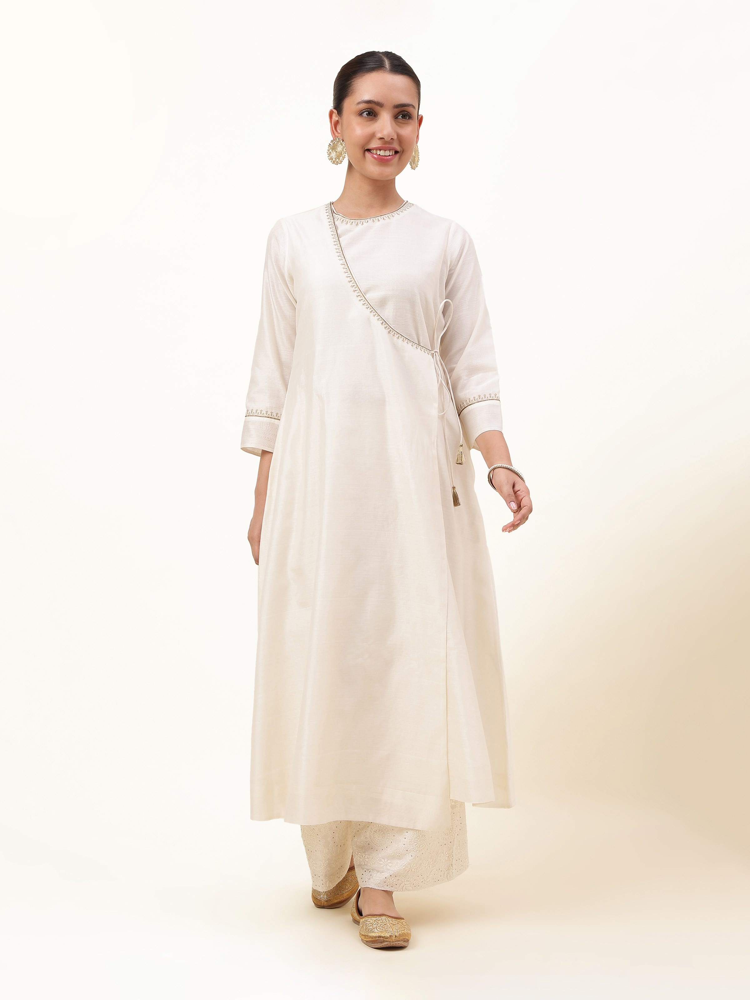 Off-white Cotton Silk Chanderi A-Line Angrakha Kurta with tie-up detail and subtle golden motifs displayed on hanger.