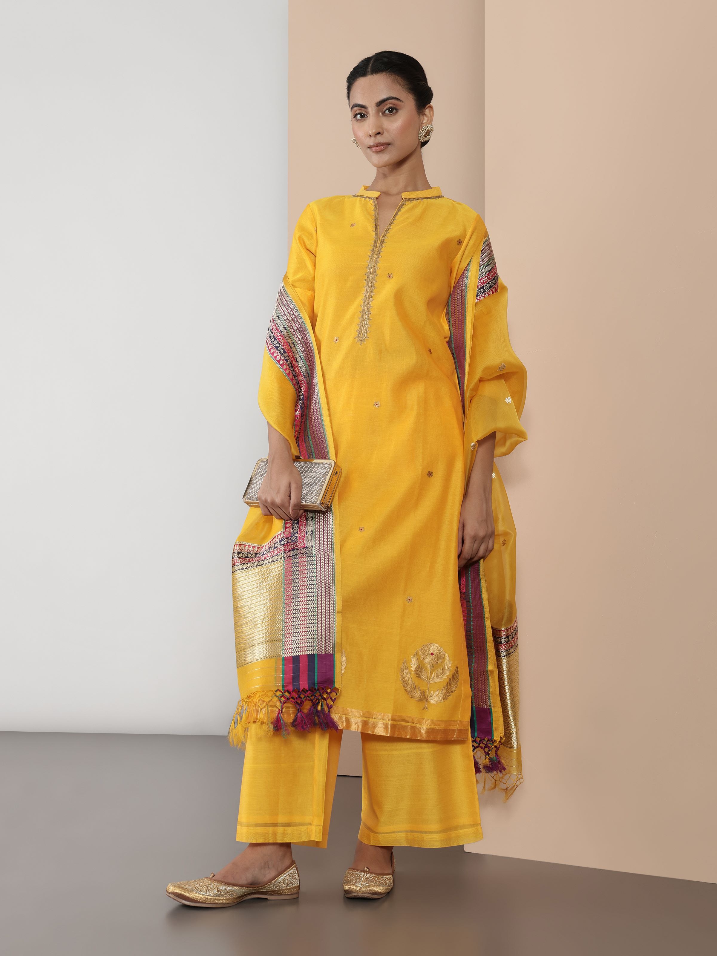 Lifestyle image of yellow Chanderi A-line kurta styled with churidar for a festive ethnic look.