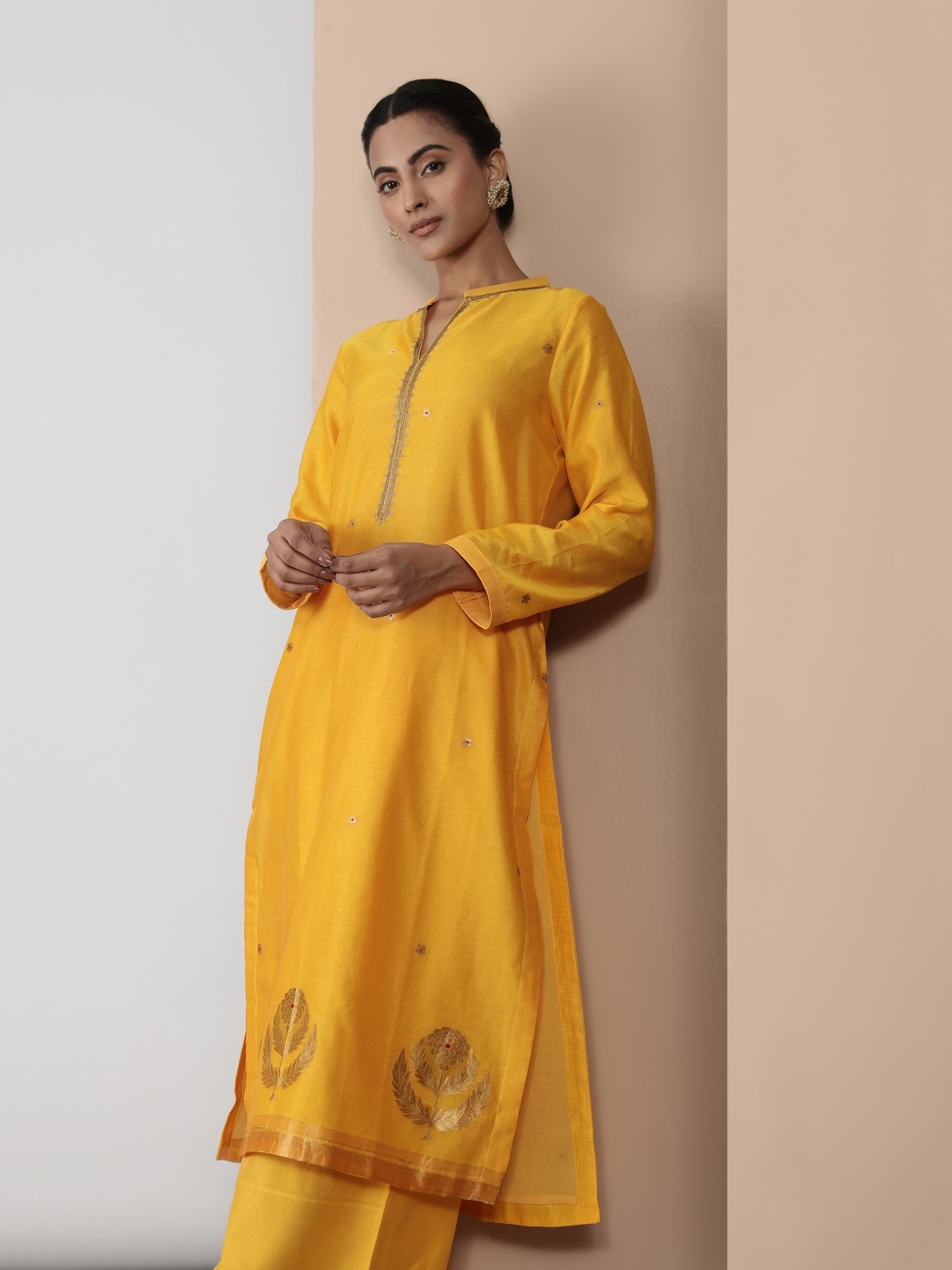 Side lifestyle view of yellow cotton silk kurta highlighting its A-line silhouette and soft texture.
