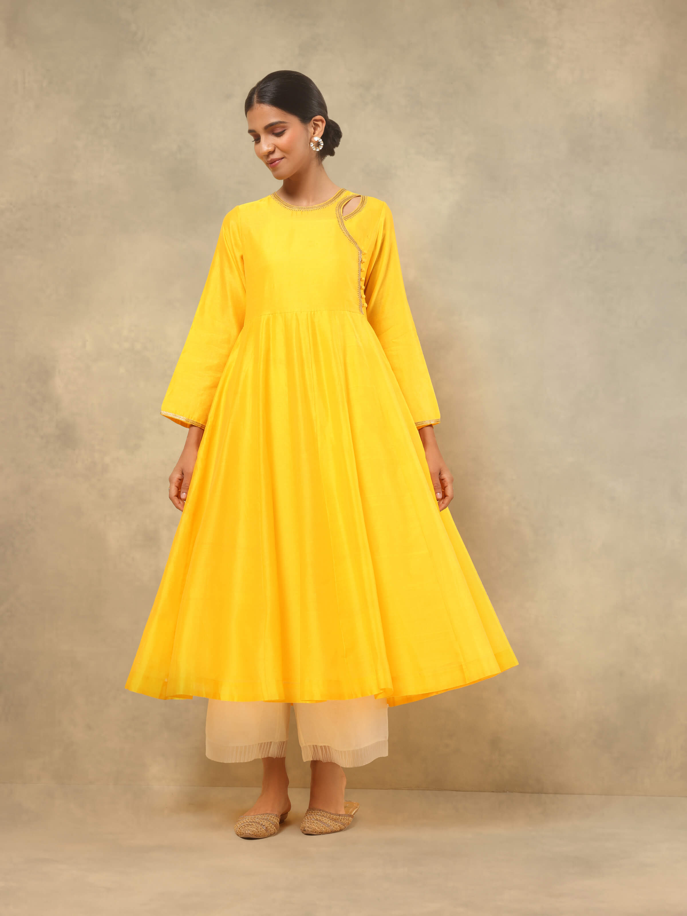 Lifestyle view of yellow Angrakha Chanderi kurta paired with white pants